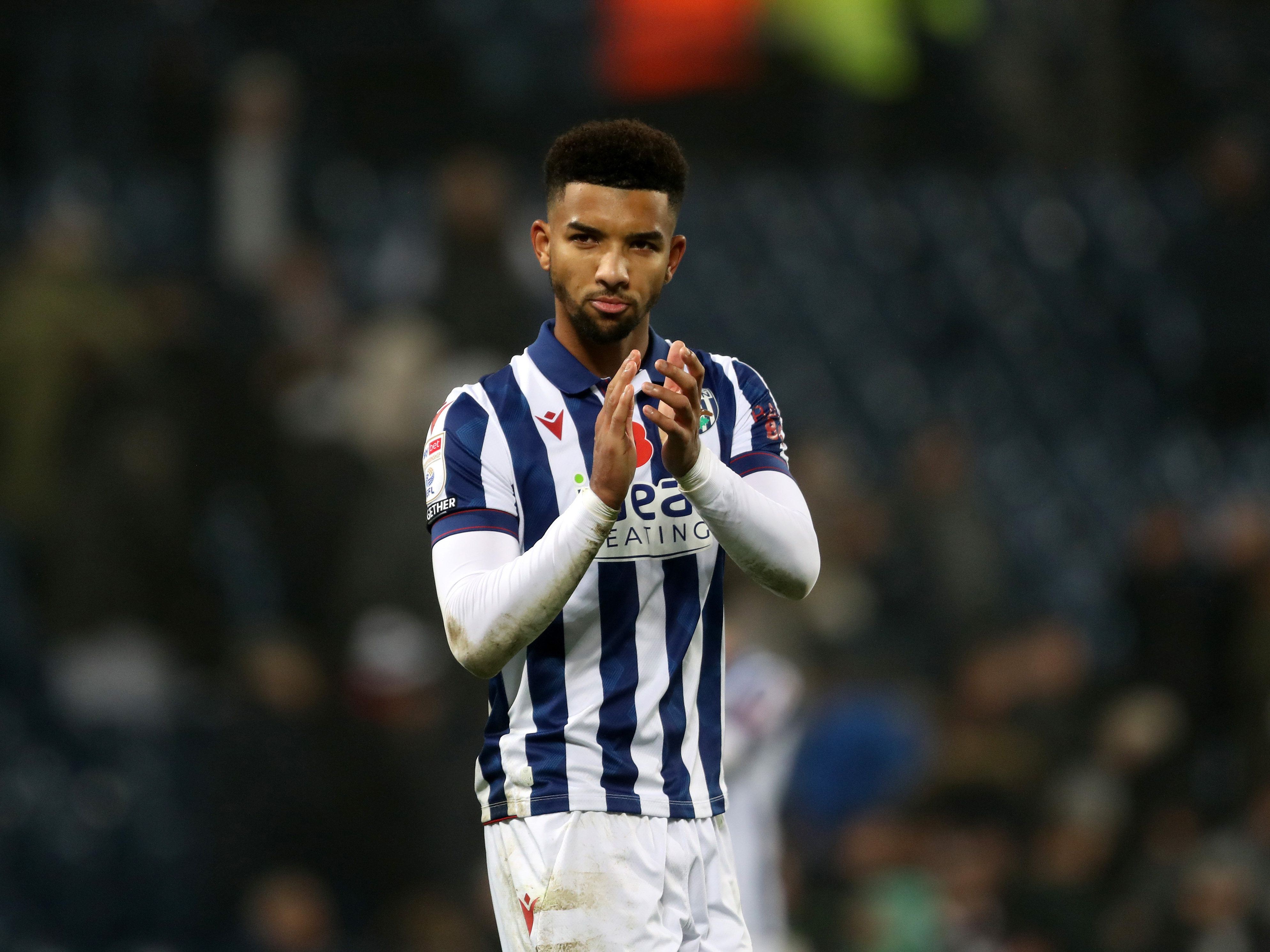 Mason Holgate applauding Albion fans at The Hawthorns while wearing the home kit 