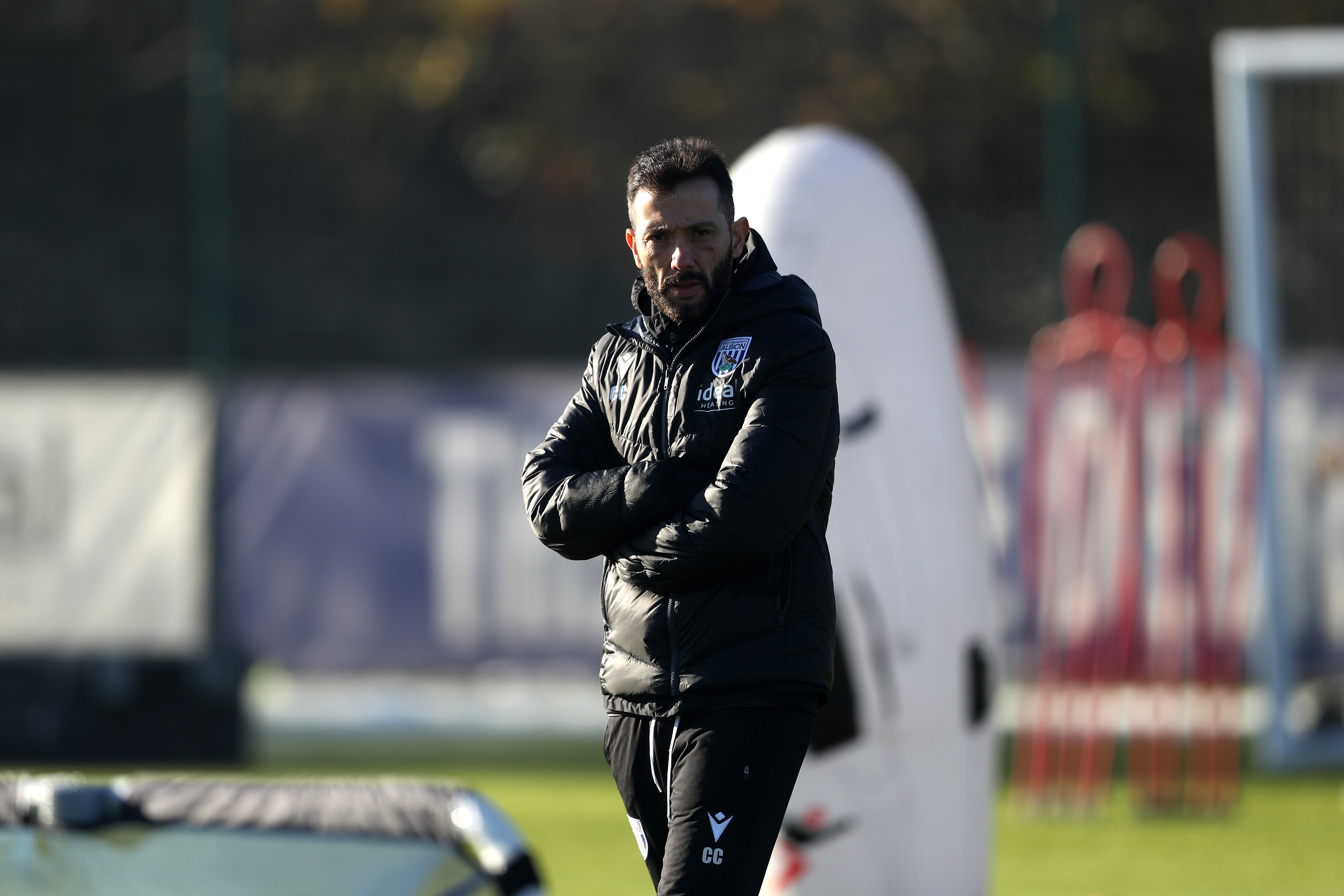 Carlos Corberán with his arms folded watching a training session 