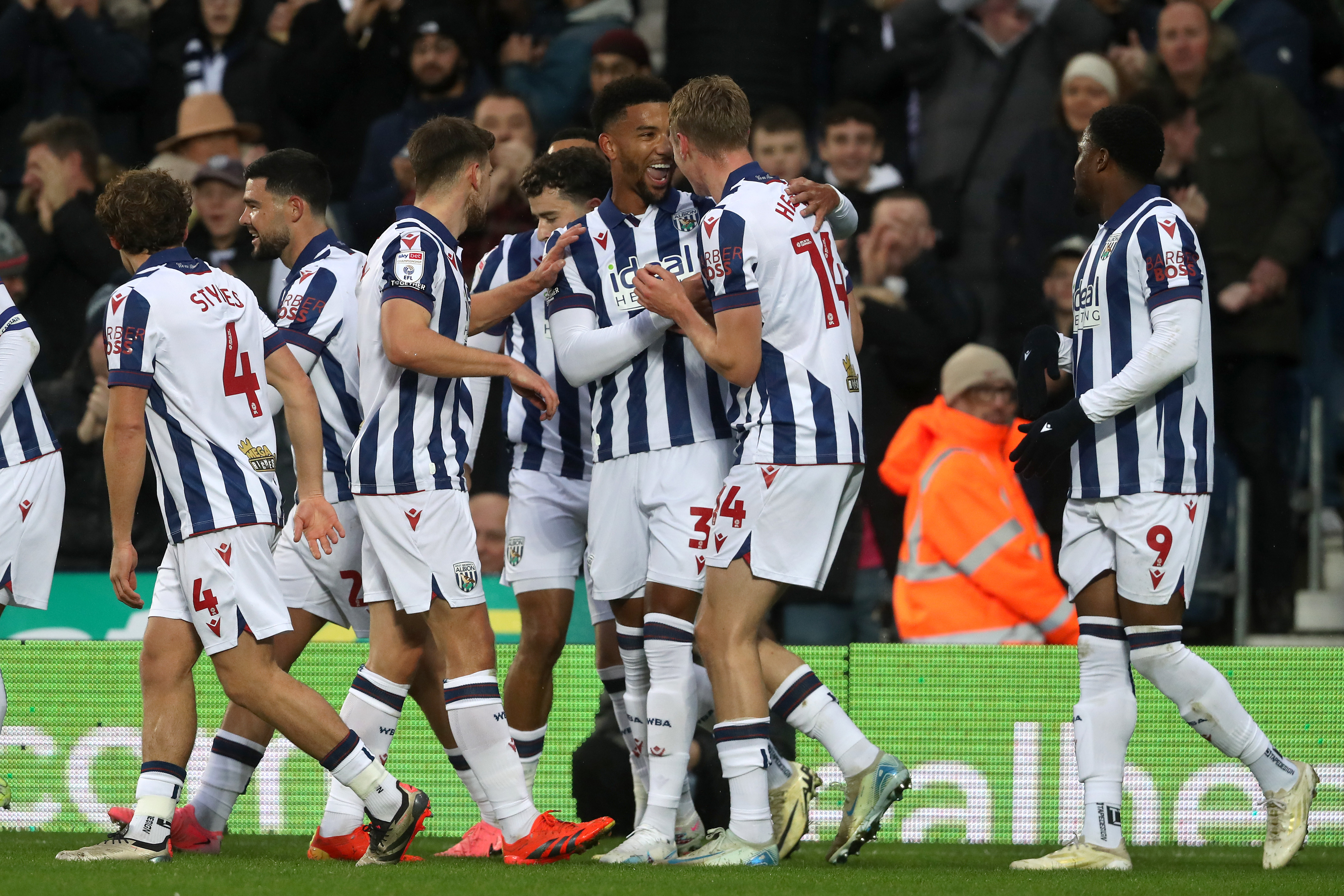 A general view of several Albion players celebrating a goal while wearing home kit at The Hawthorns 