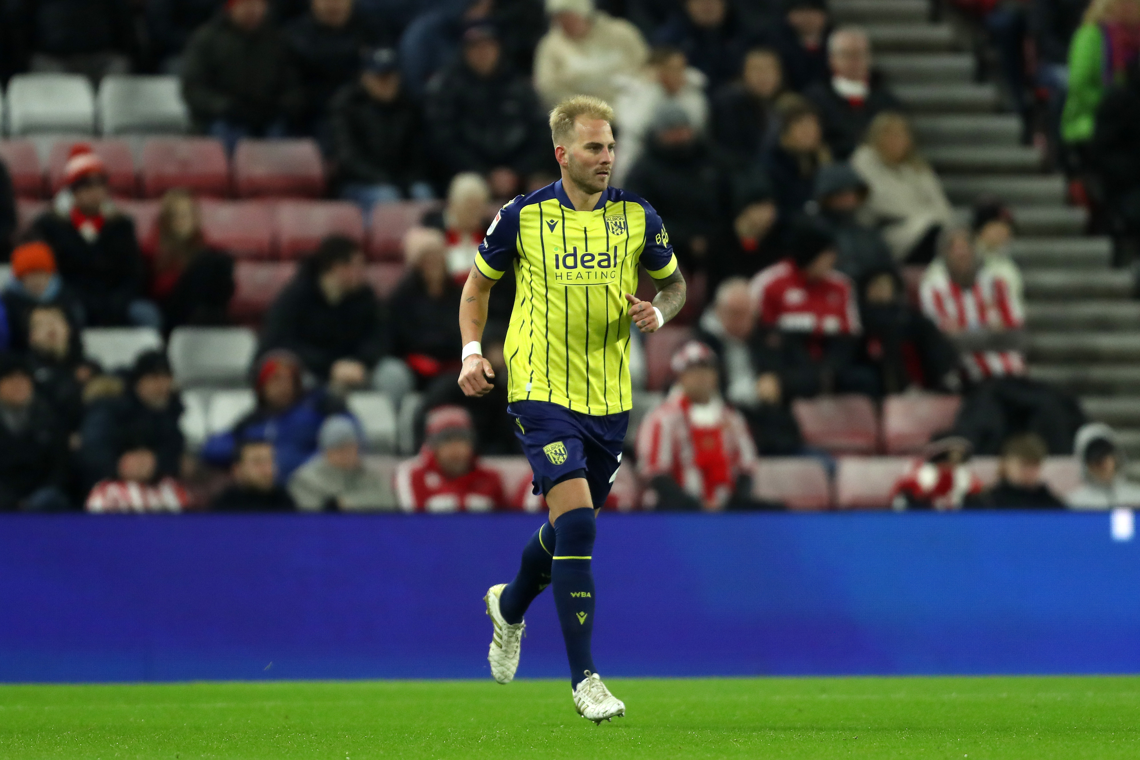 Uroš Račić in action for Albion at Sunderland in the yellow and blue away kit 