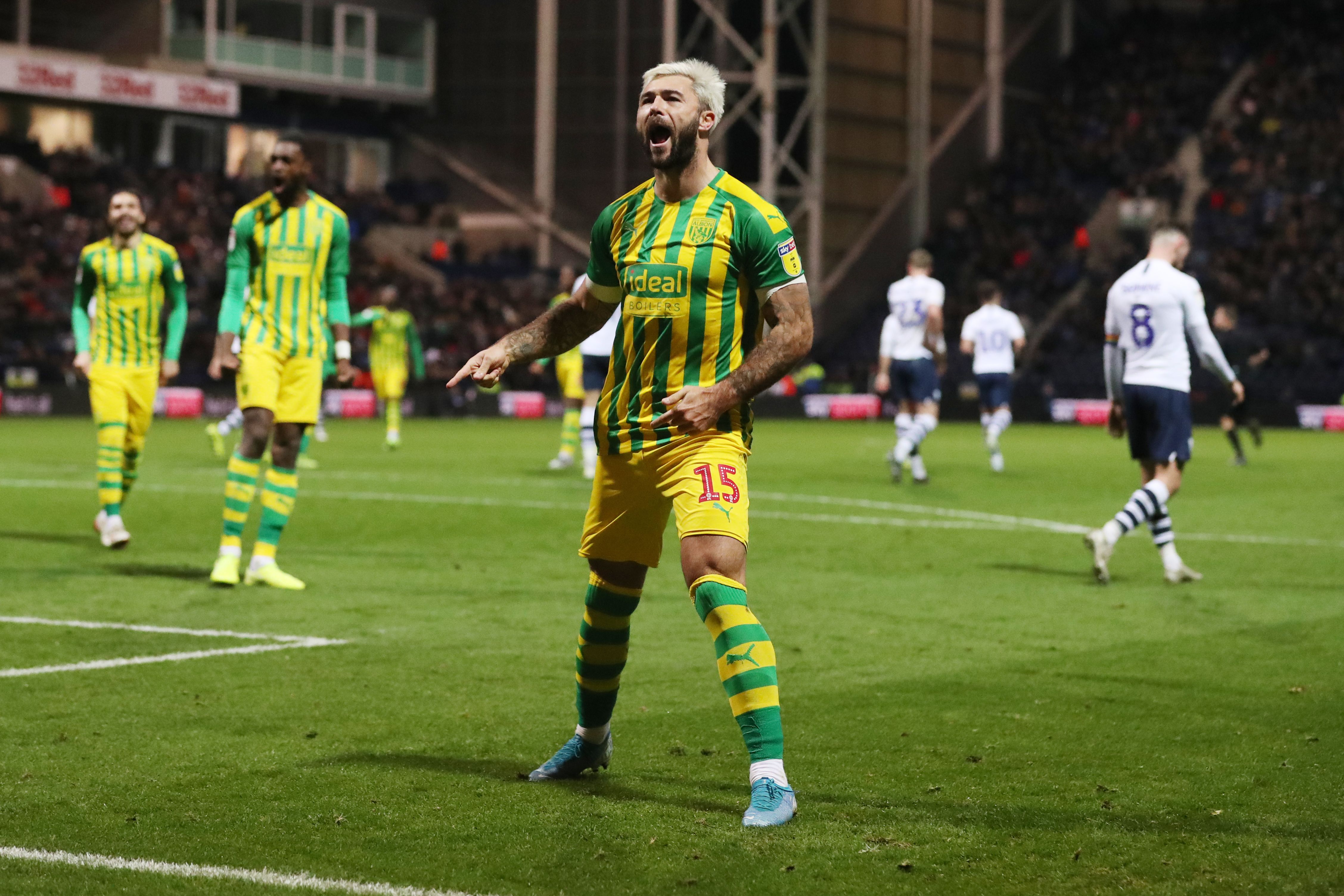 Charlie Austin in a green and yellow away Albion kit celebrates scoring a penalty at Deepdale in December 2019