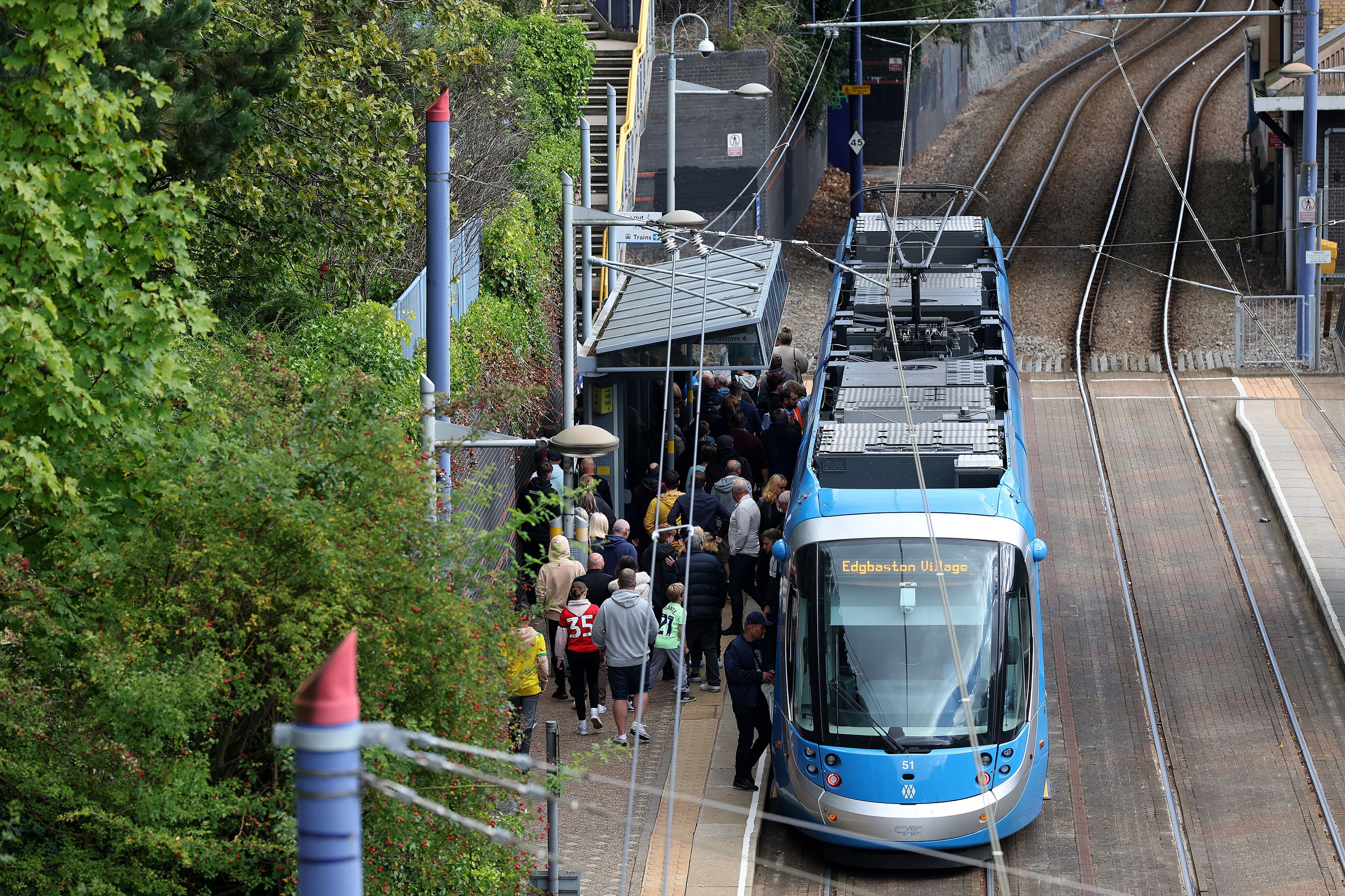 A general view of supporters getting off a tram at a tram station