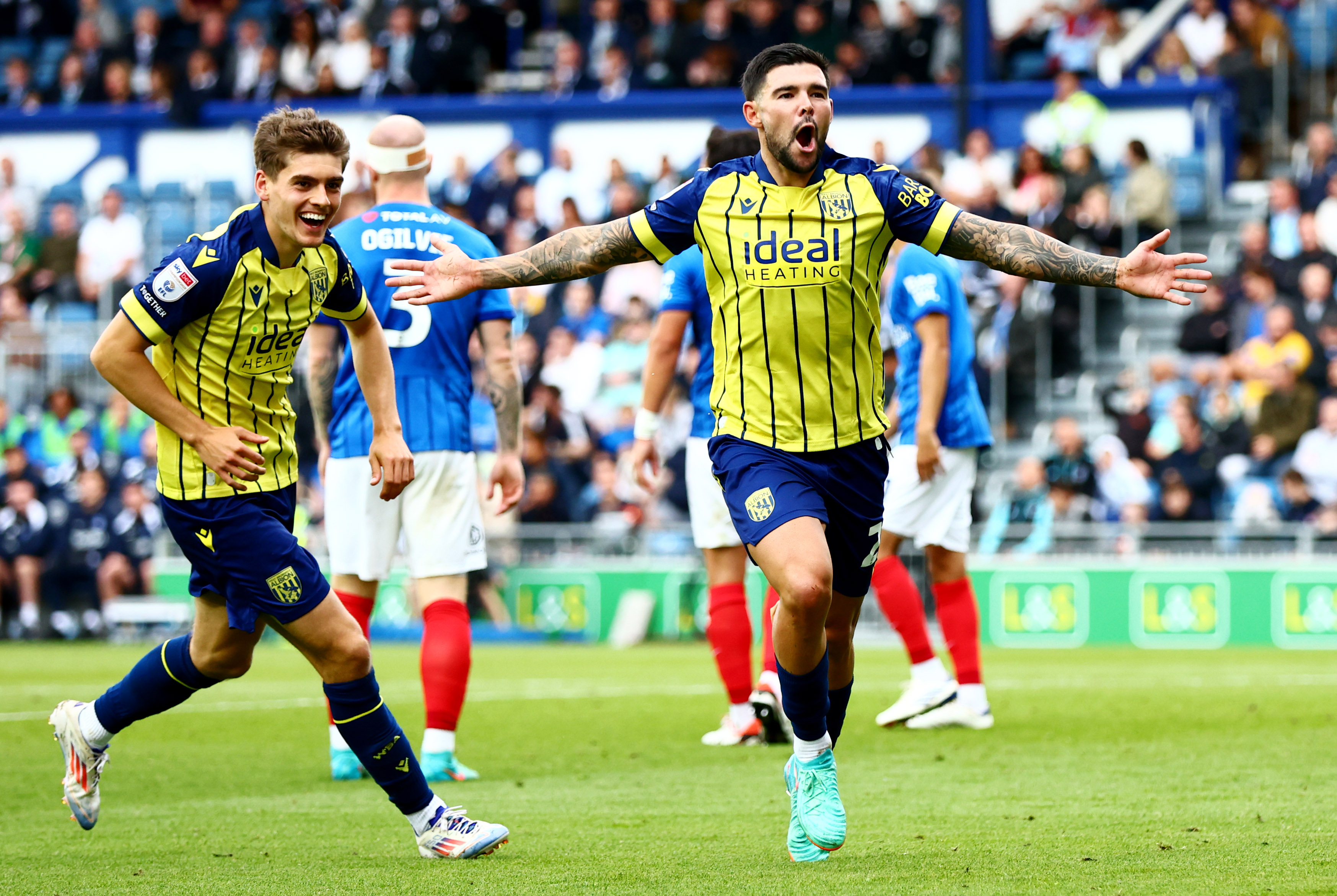 Alex Mowatt celebrates with Tom Fellows after scoring in the yellow and blue away kit at Portsmouth 