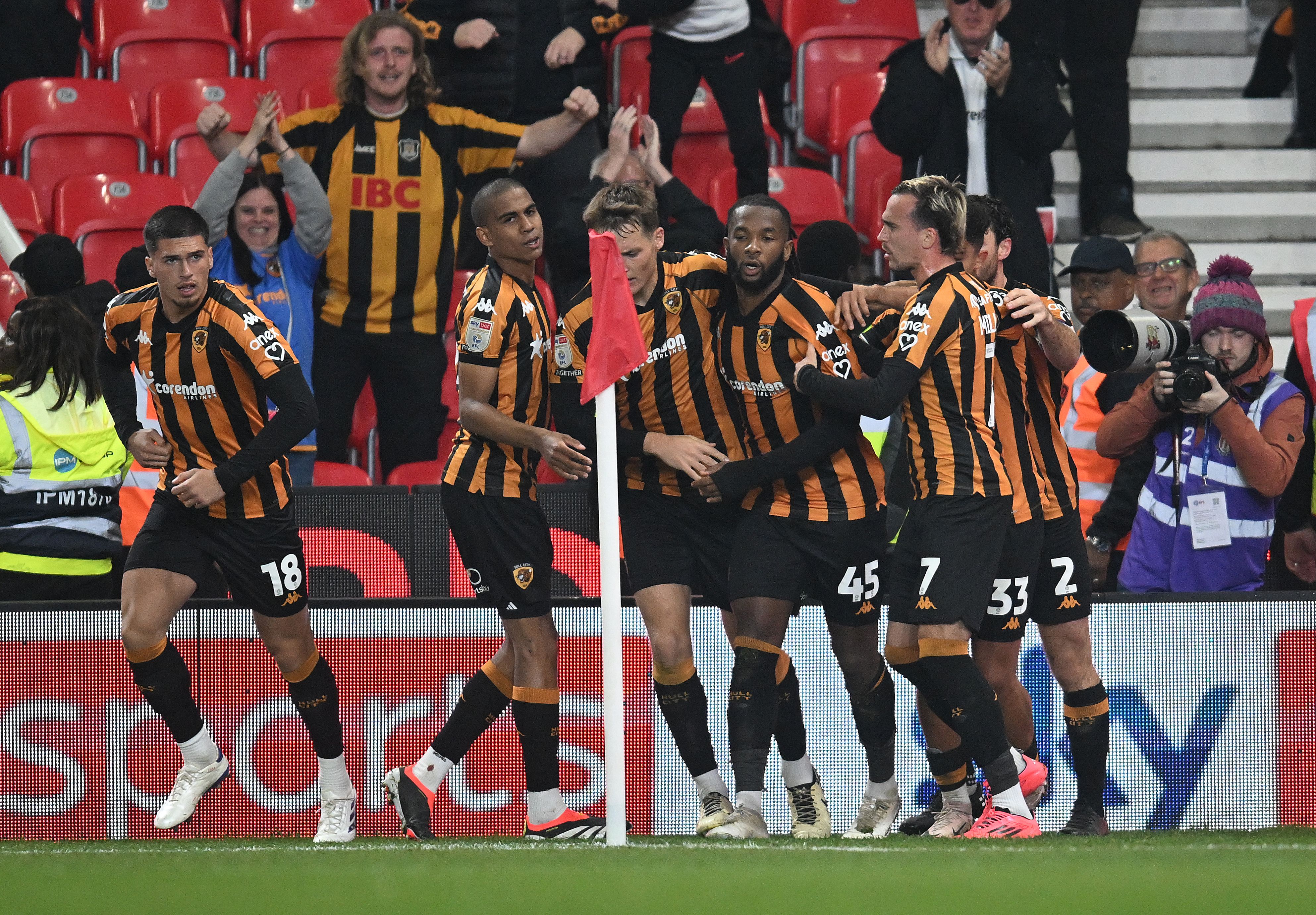 A general view of several Hull City players celebrating a goal by a corner flag at Stoke City 