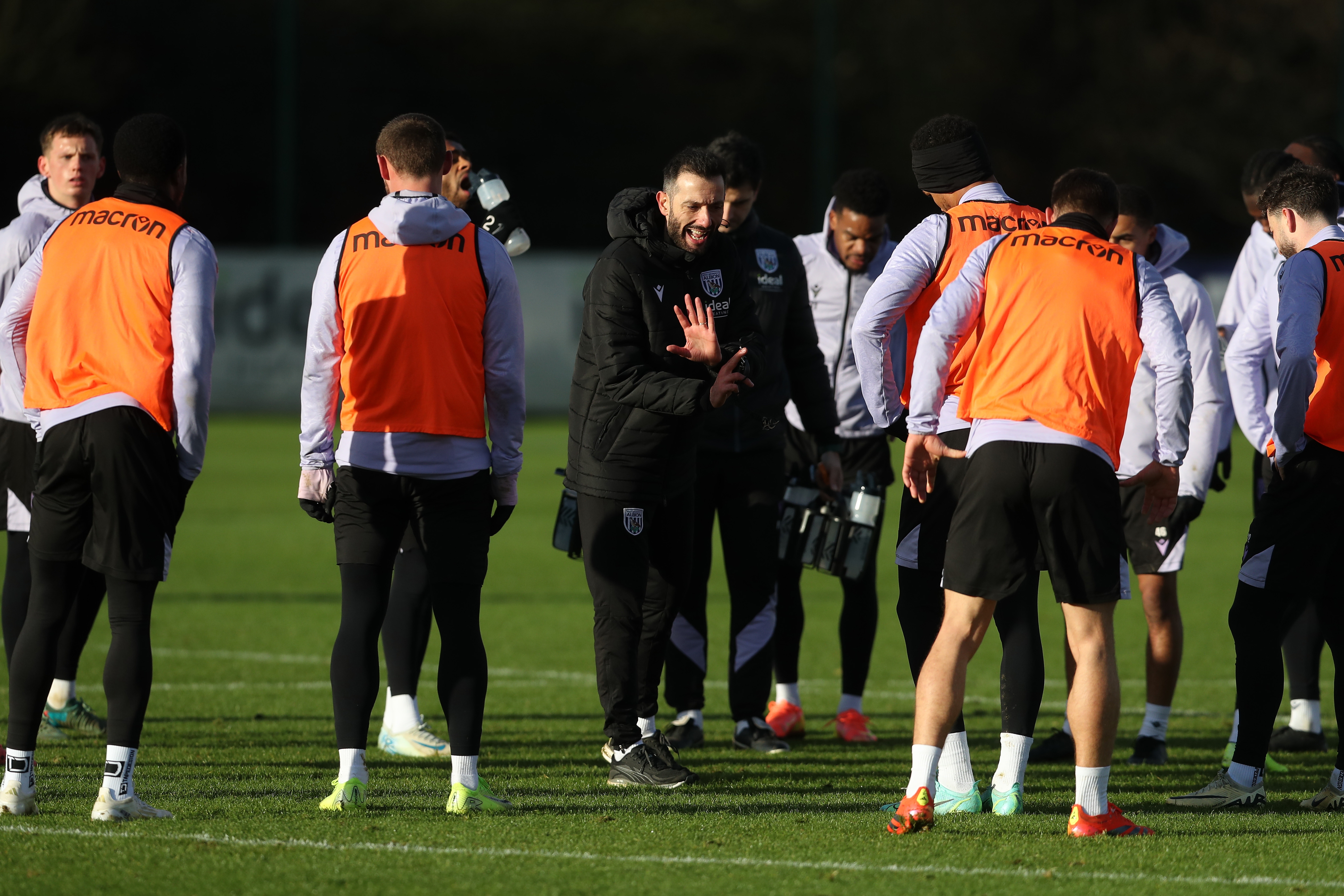 Carlos Corberán delivering a message to several players in the middle of a session 