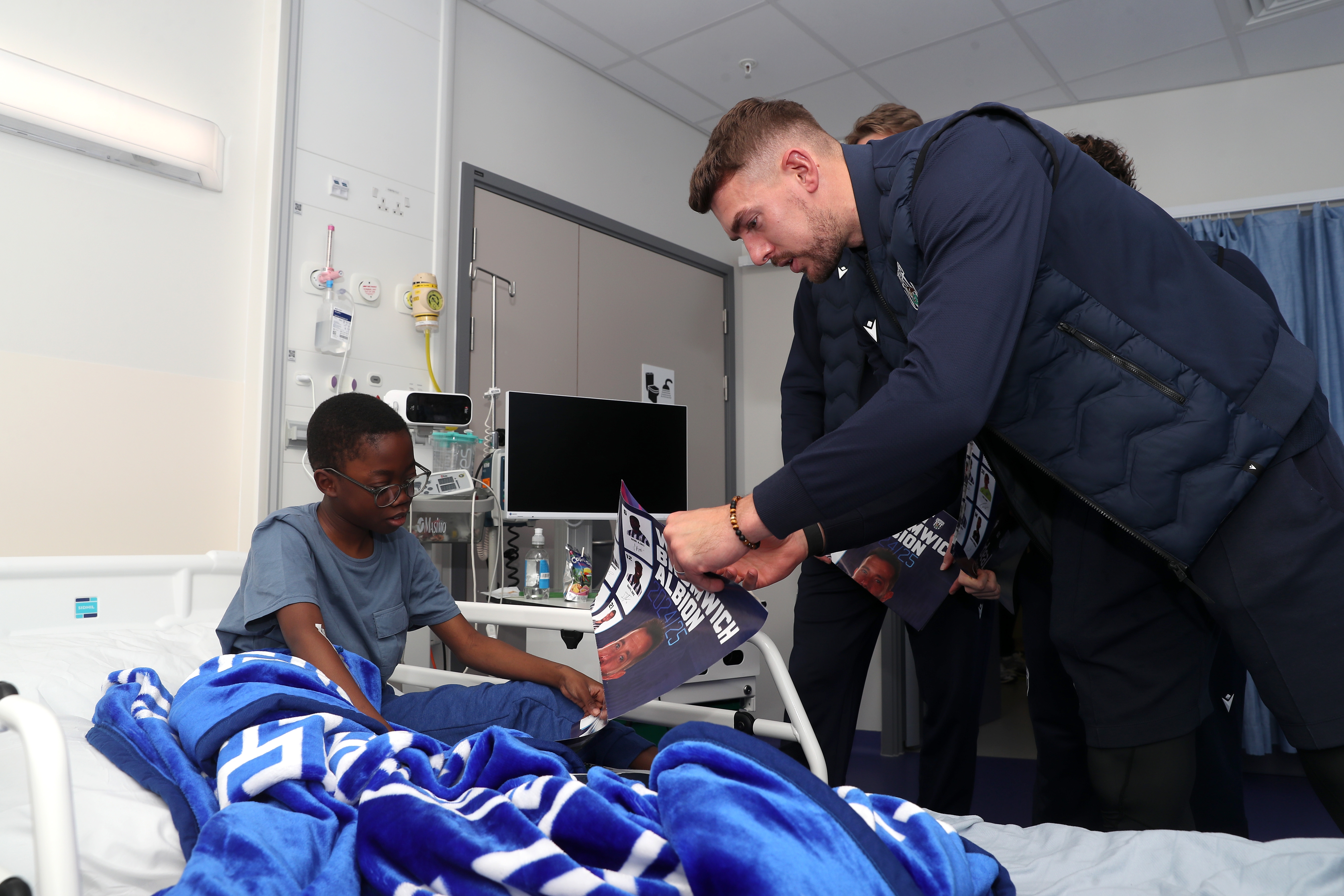 Alex Palmer speaks with a young patient at Midlands Metropolitan University Hospital 