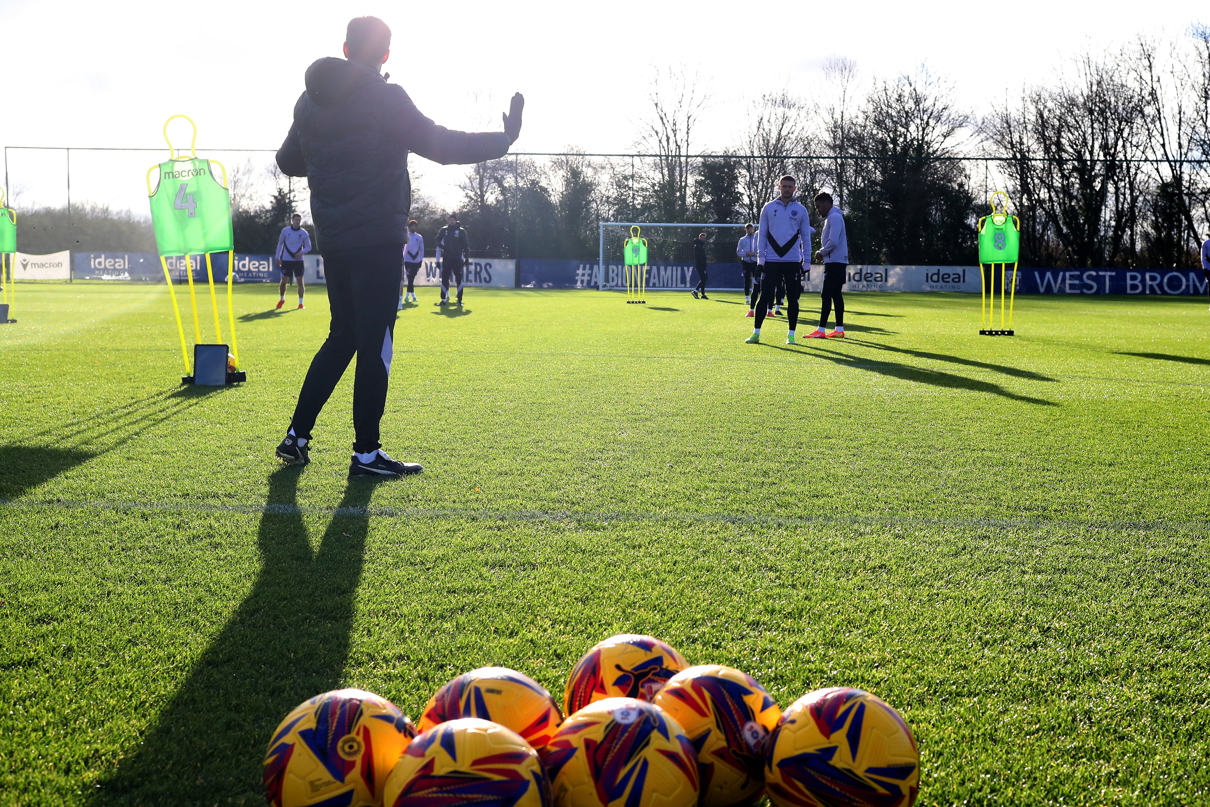 A general view of training with yellow footballs at the front 