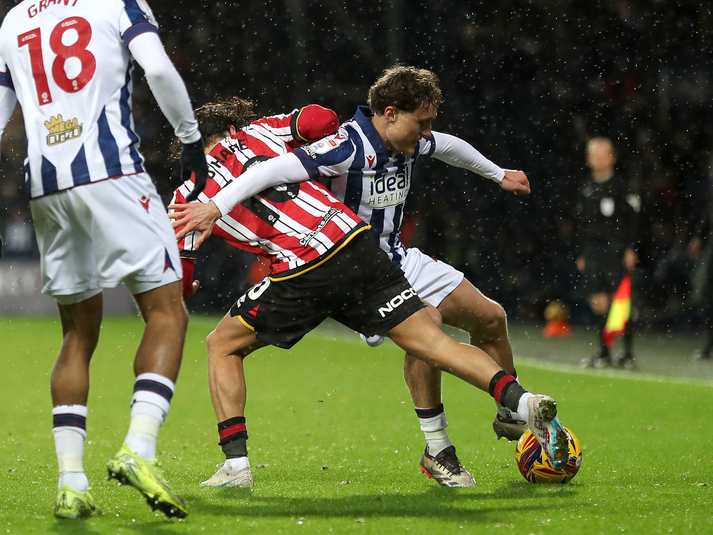 Callum Styles battles for the ball with a Sheffield United player in the home kit 