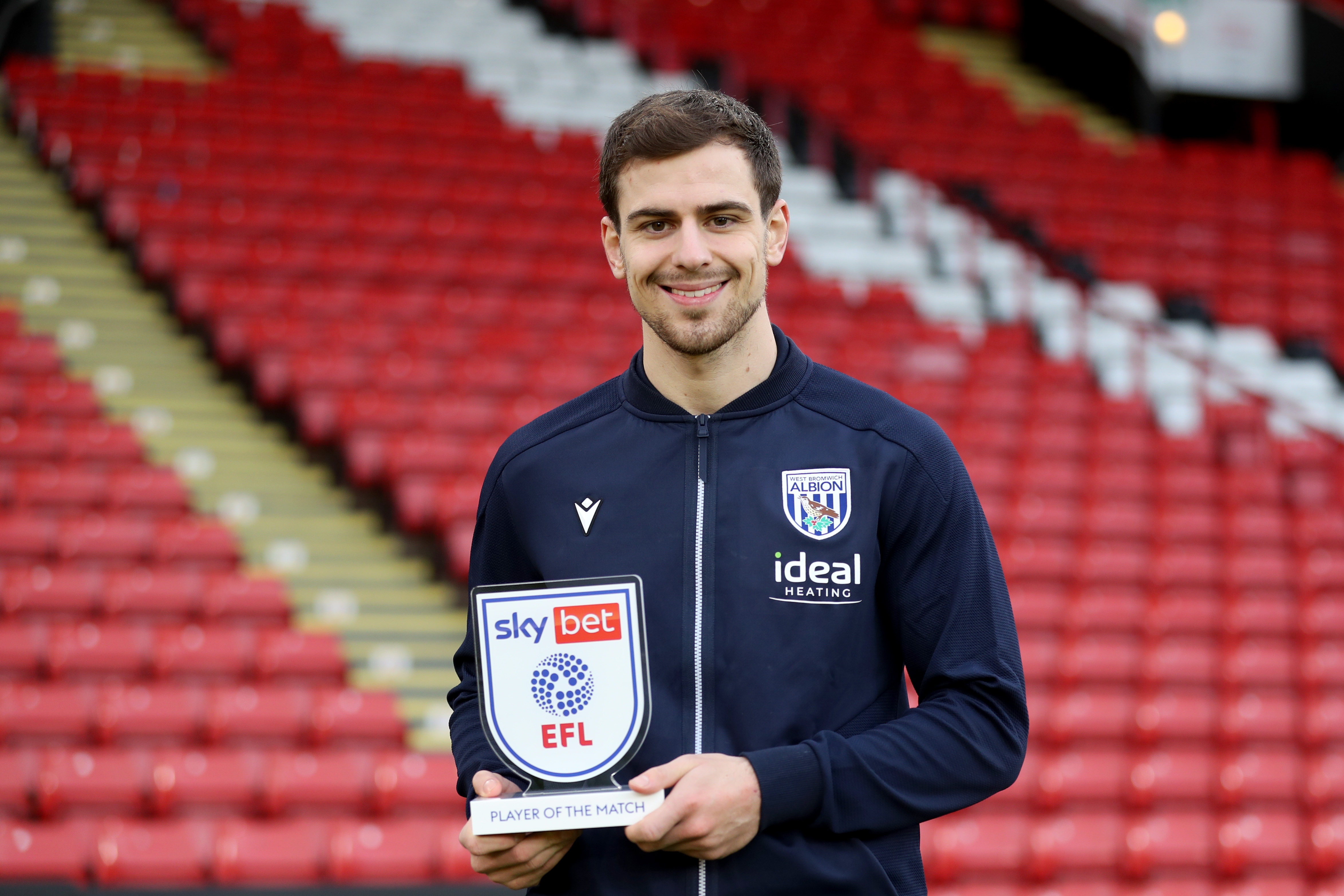 Jayson Molumby smiles at the camera with his Man of the Match award in his hand from the game against Sheffield United 