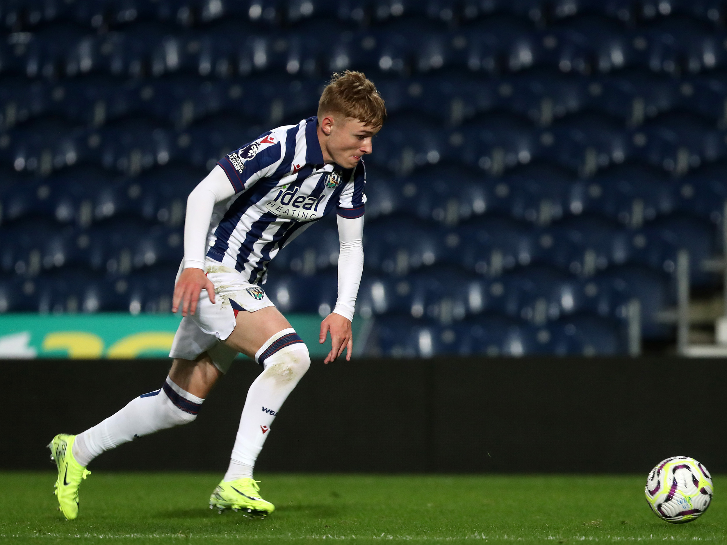 Ollie Bostock on the ball during a PL2 game at The Hawthorns in the home kit 