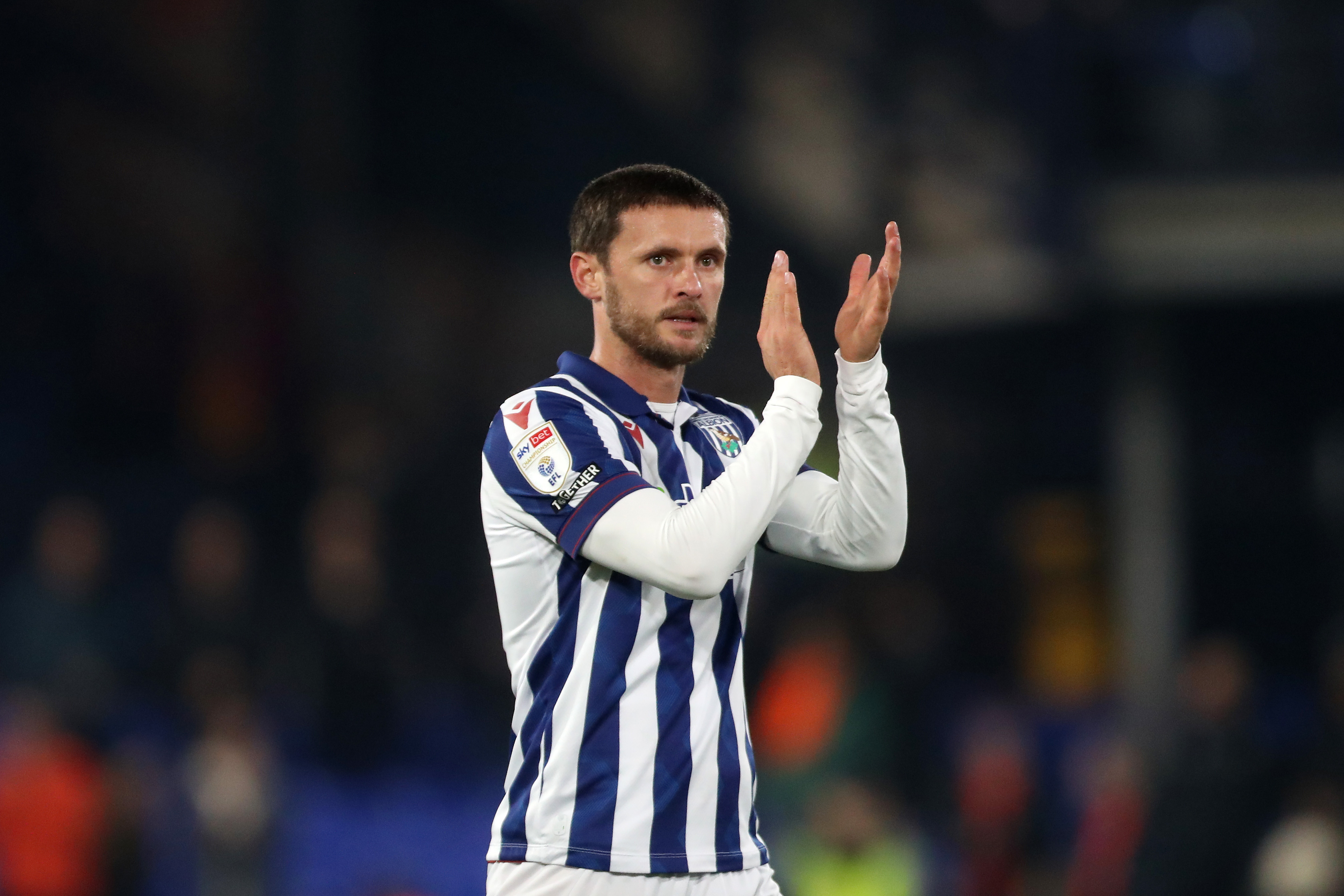 John Swift applauding Albion fans while wearing the home kit 