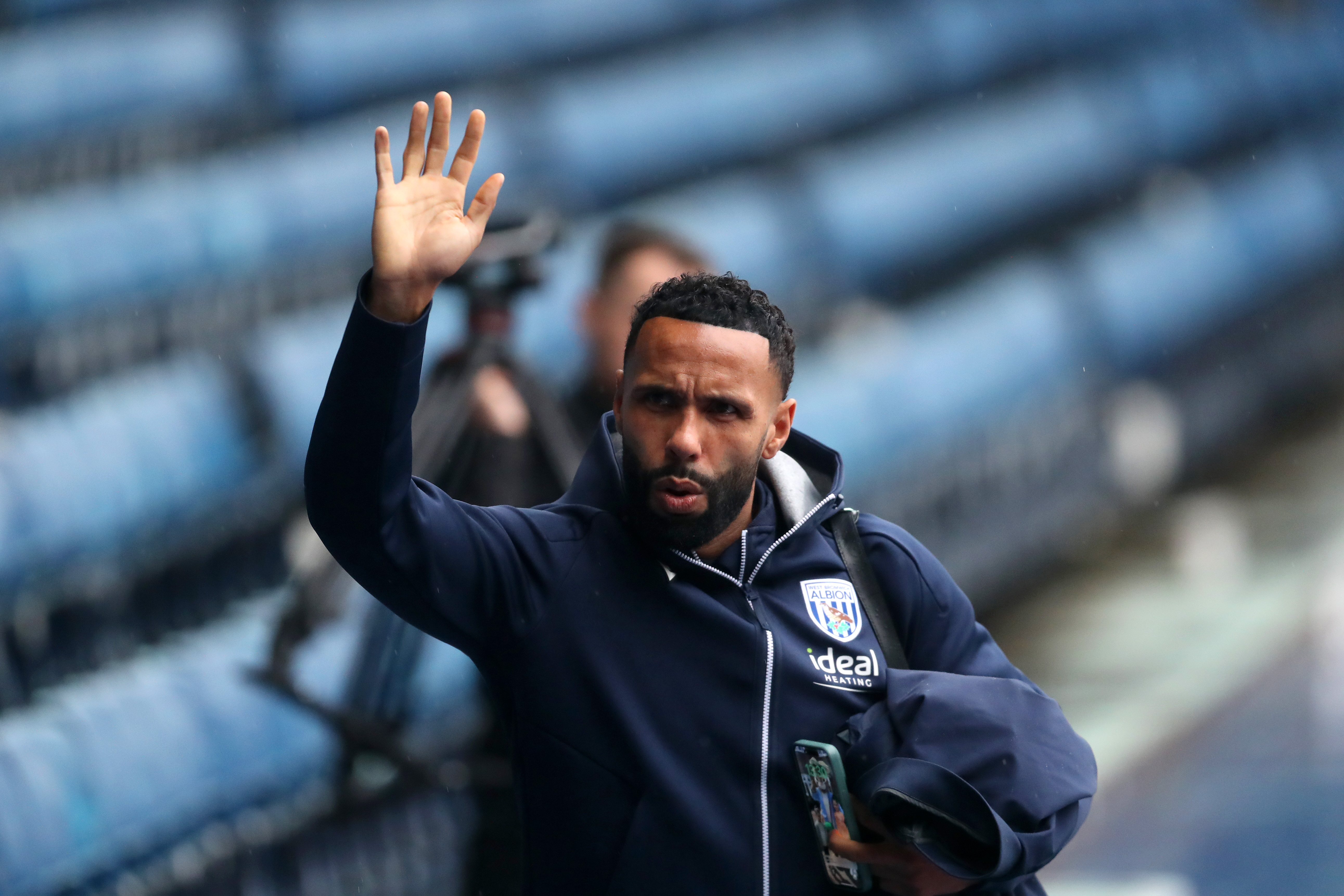 Kyle Bartley waving to fans arriving at a game in a WBA tracksuit 