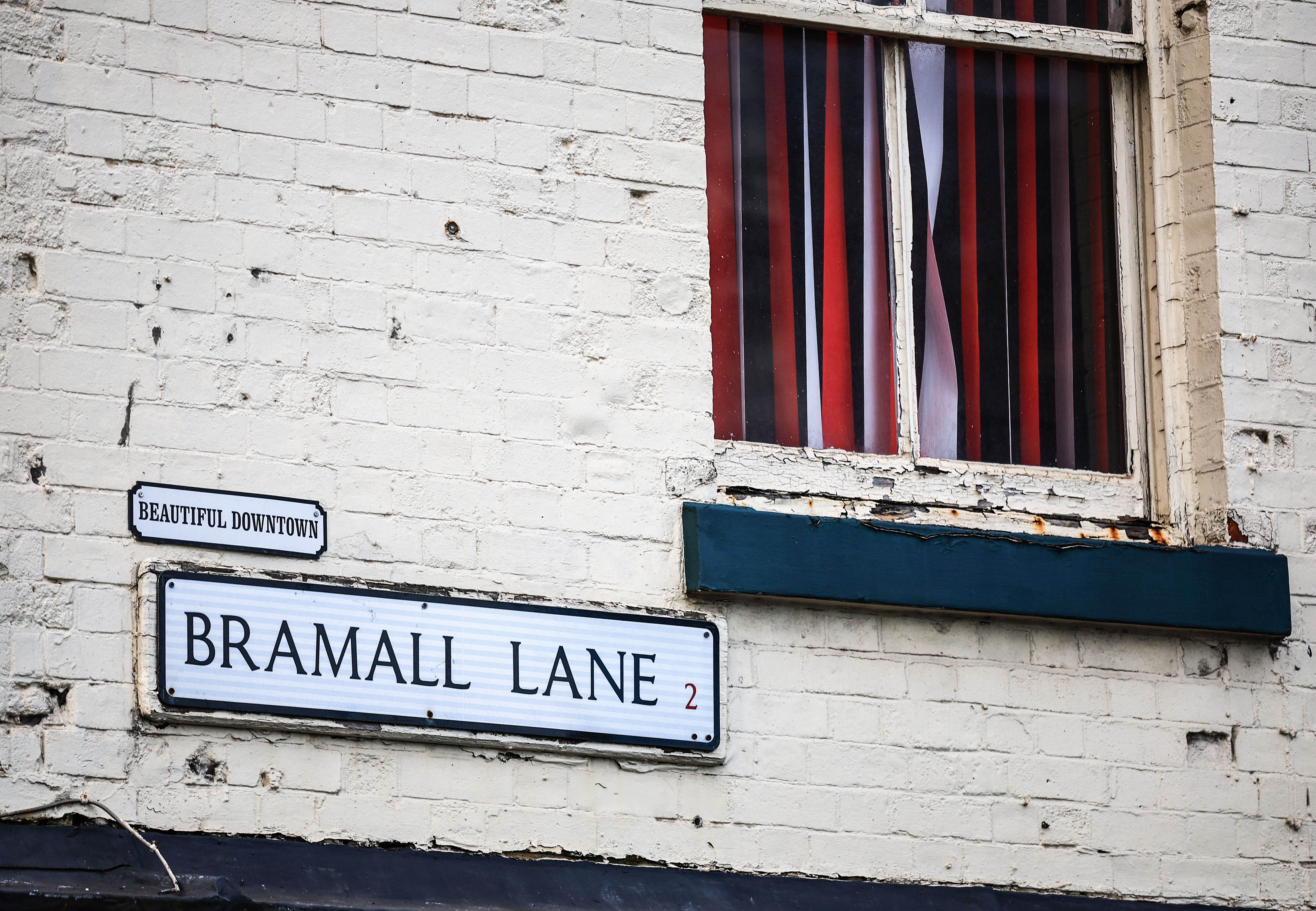 A road sign saying Bramall Lane on the side of a house 