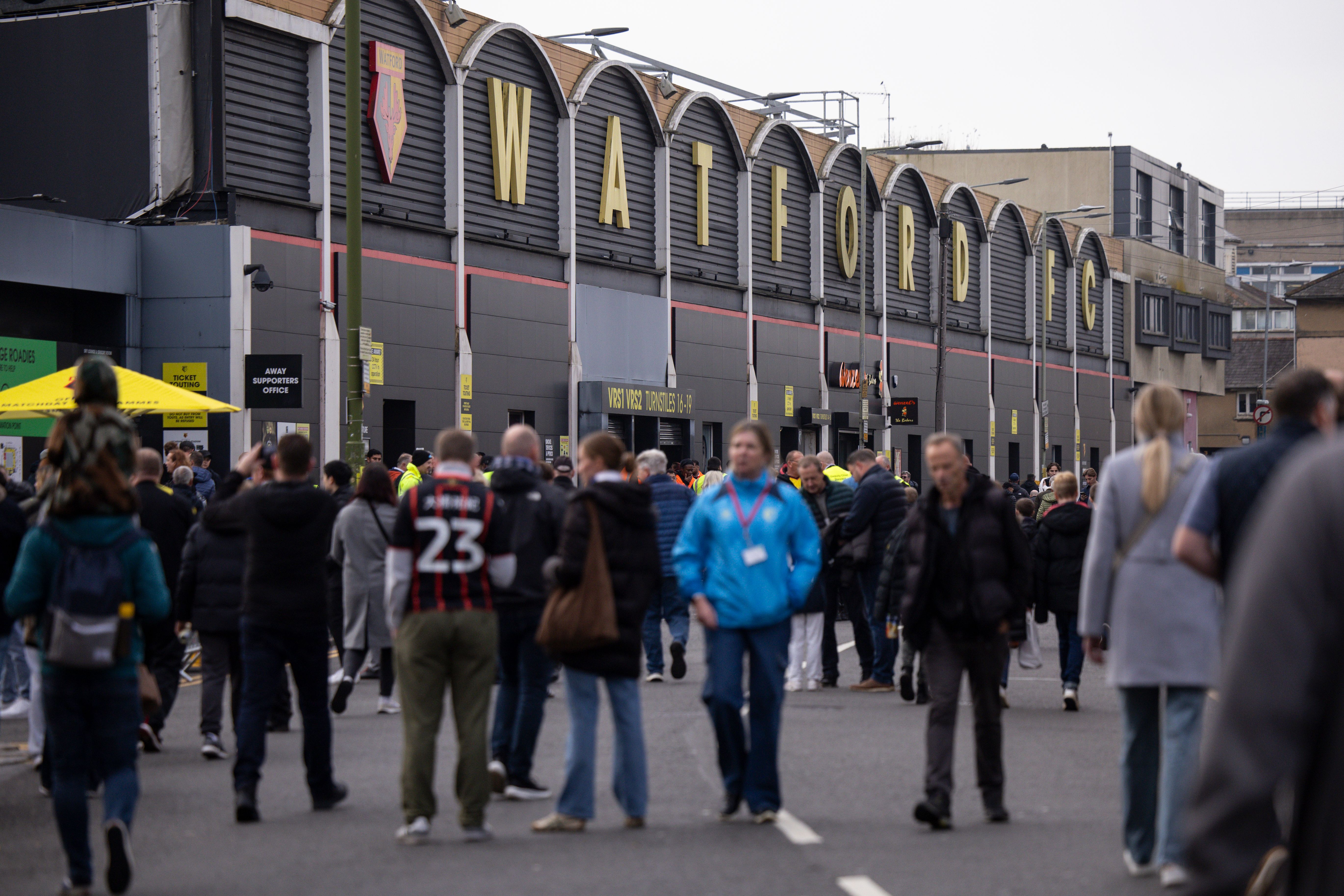 A general view of the outside of Vicarage Road with supporters walking down the road 