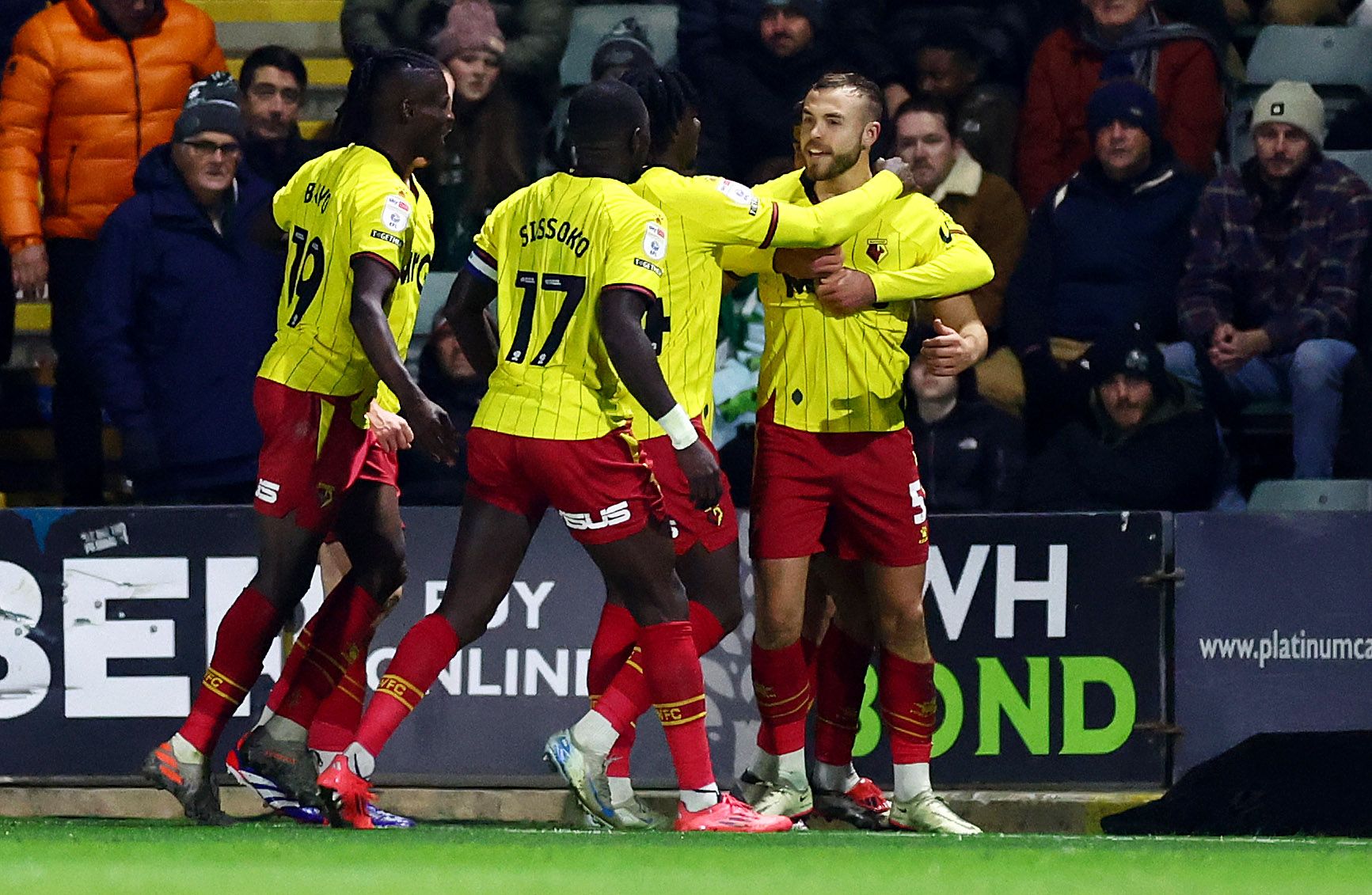 Several Watford players celebrate a goal in their home kit 