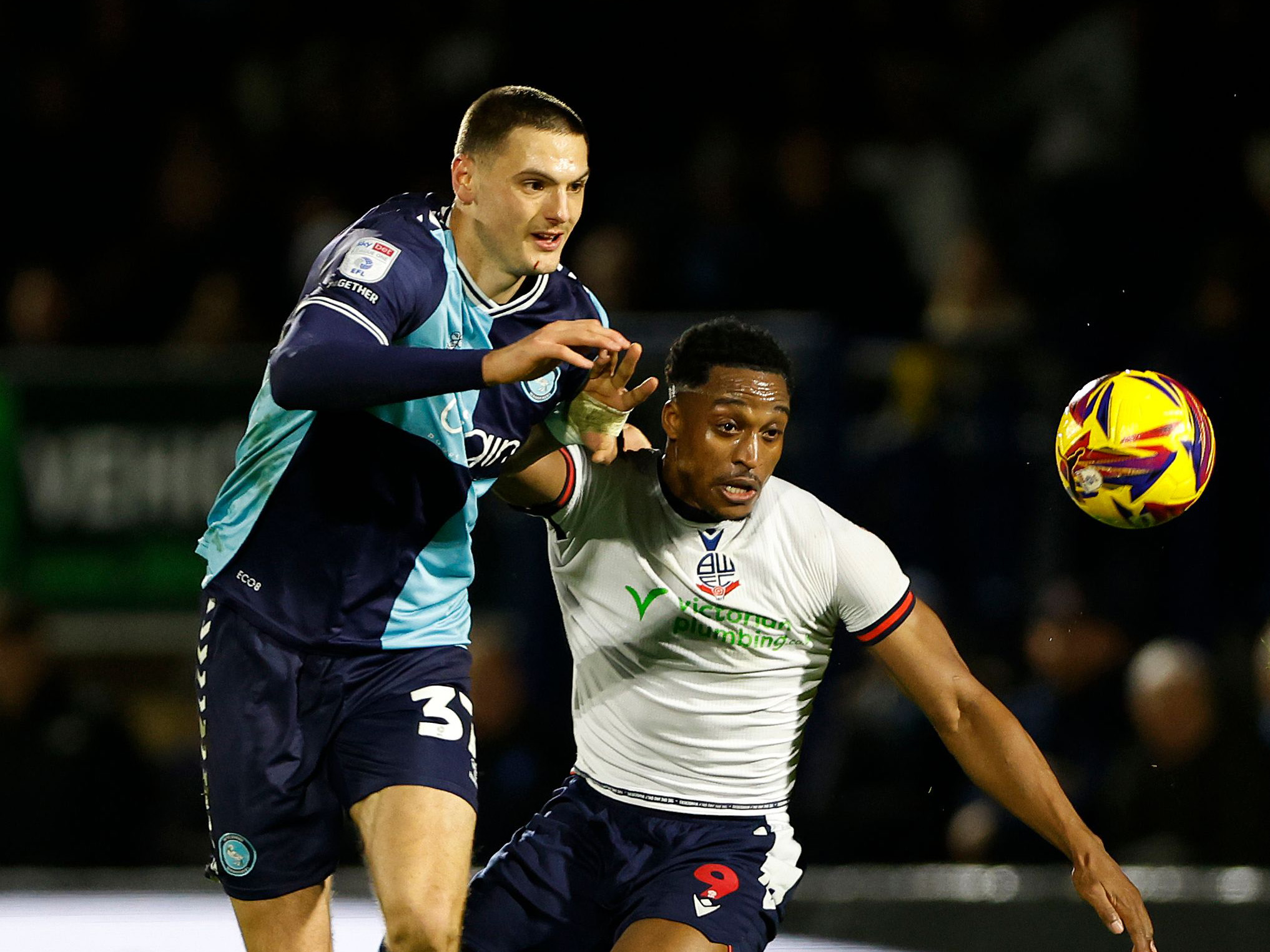 Caleb Taylor in action for Wycombe in their home kit against Bolton