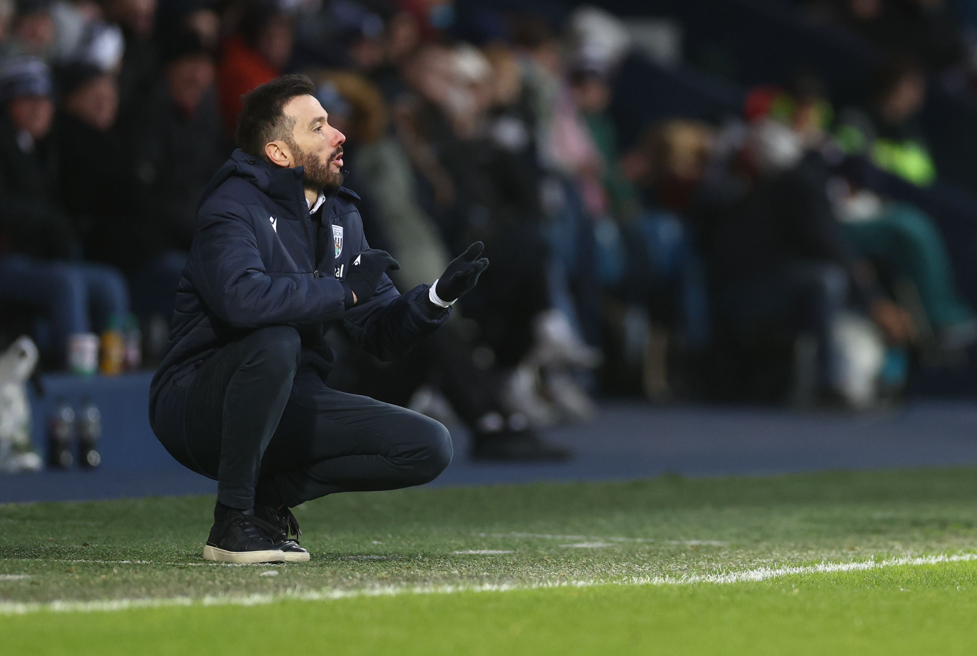 Carlos Corberán crouched down on the side of the pitch against Bristol City 