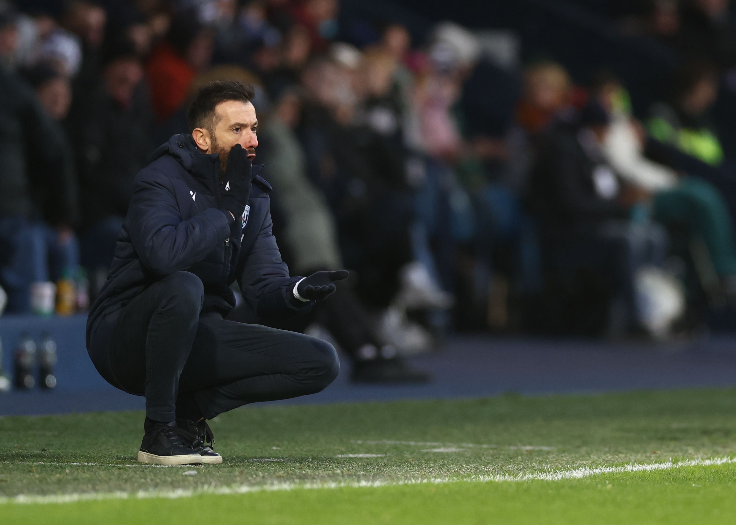 Carlos Corberán crouched down on the side watching the Bristol City game 