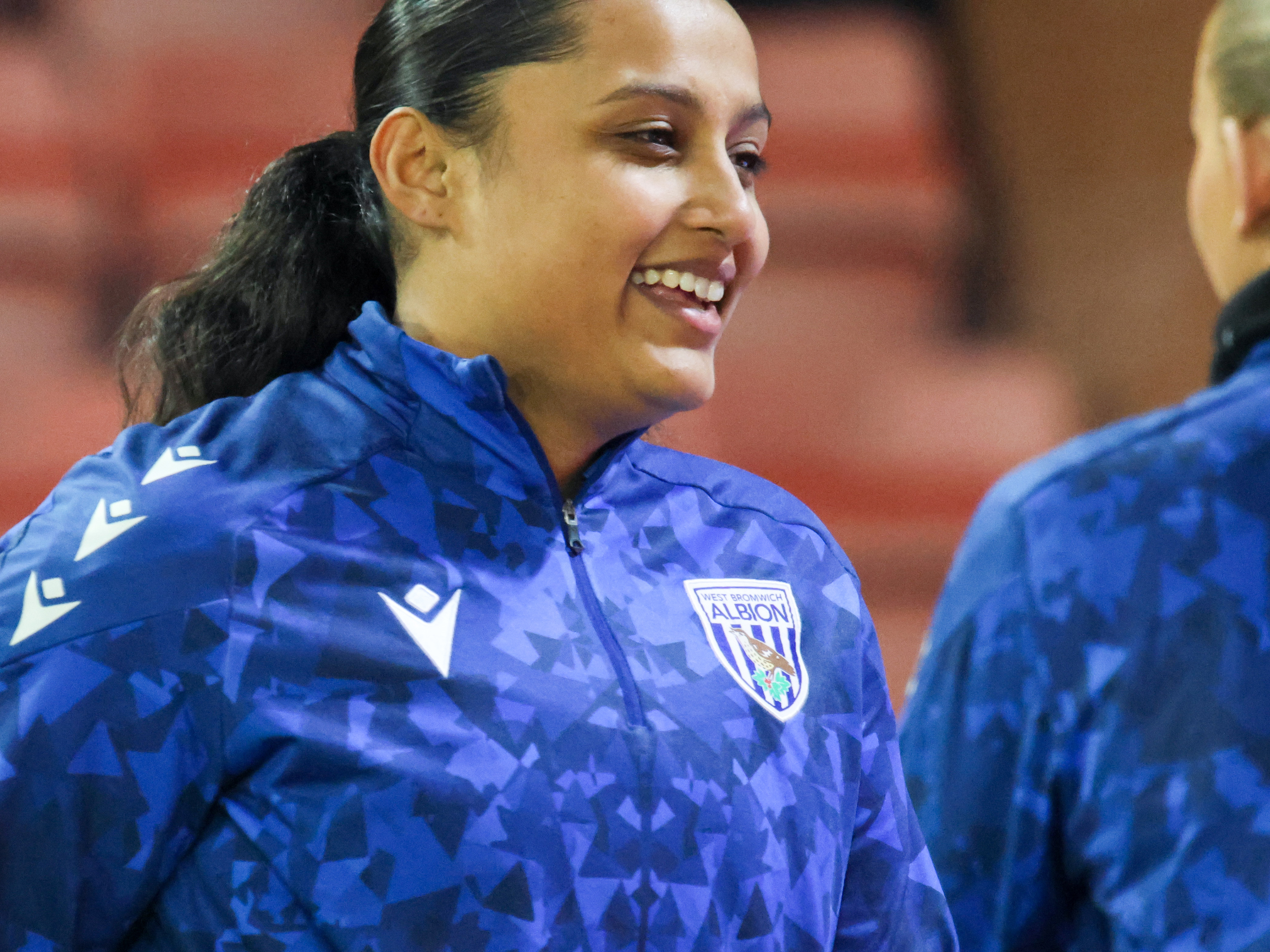 Simran Jhamat smiling during a pre-match warm-up 