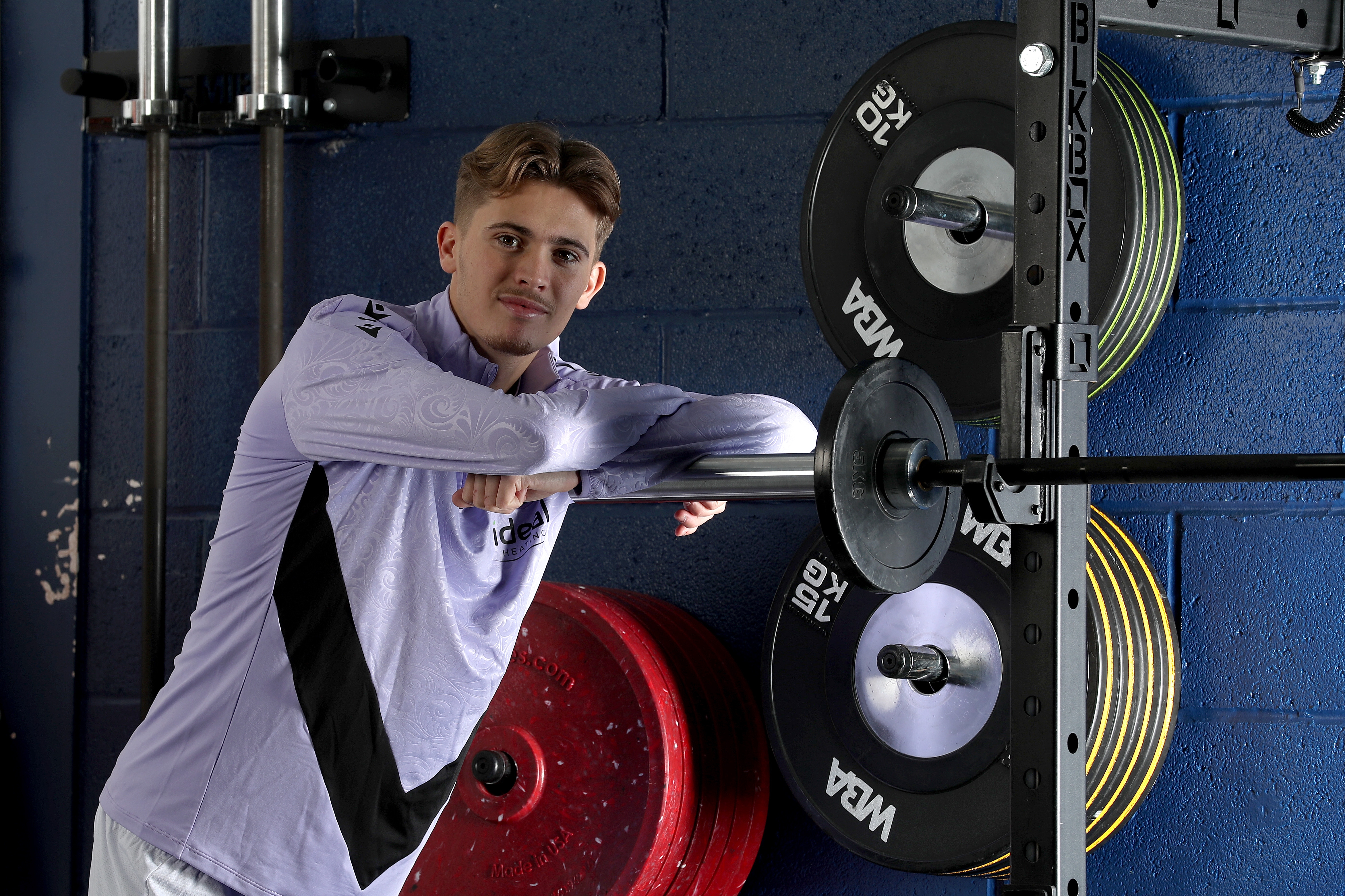 Isaac Price in Albion training gear leaning on equipment in the gym