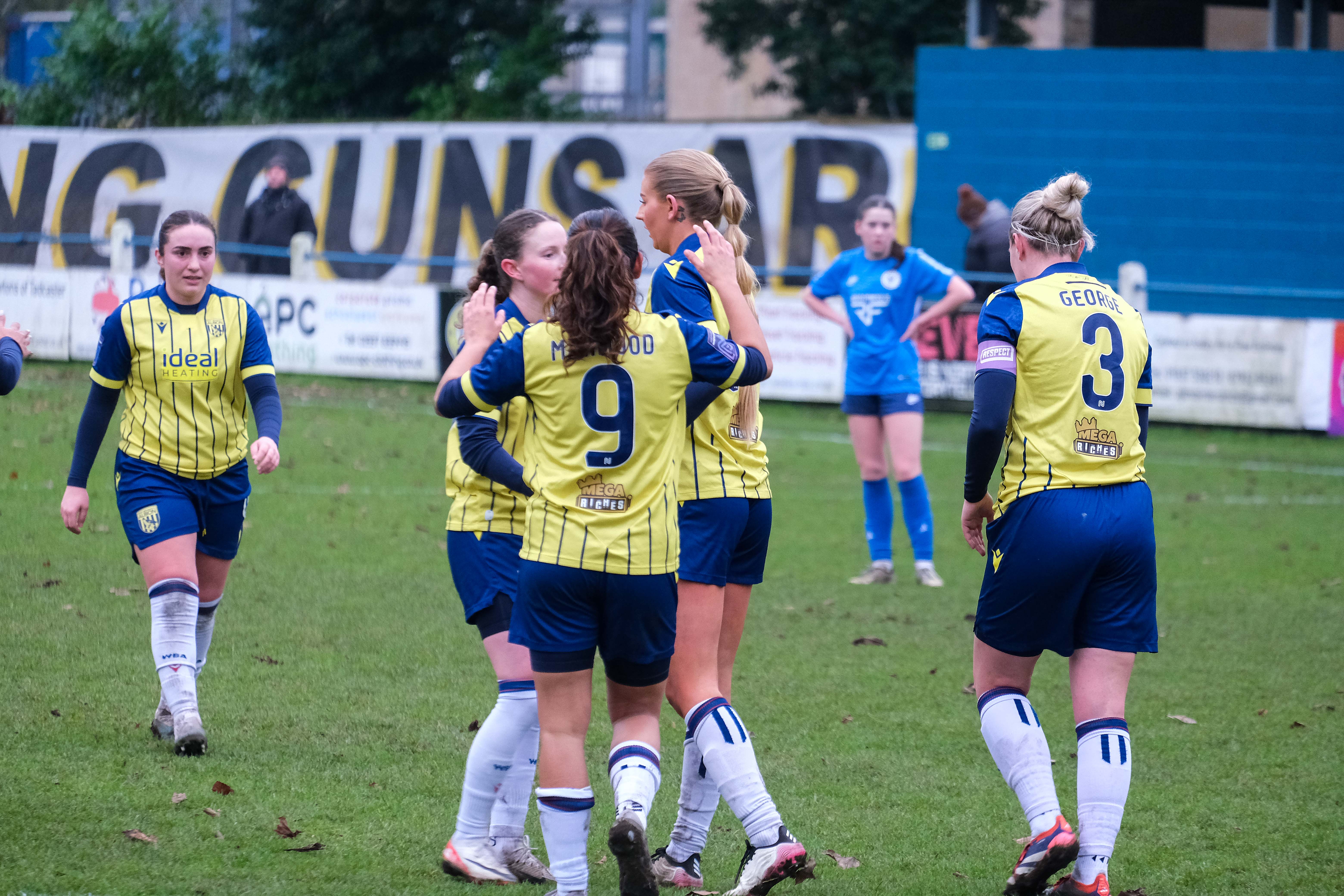 Several Albion players wearing the yellow and navy blue away kit celebrate a goal scored at Halifax