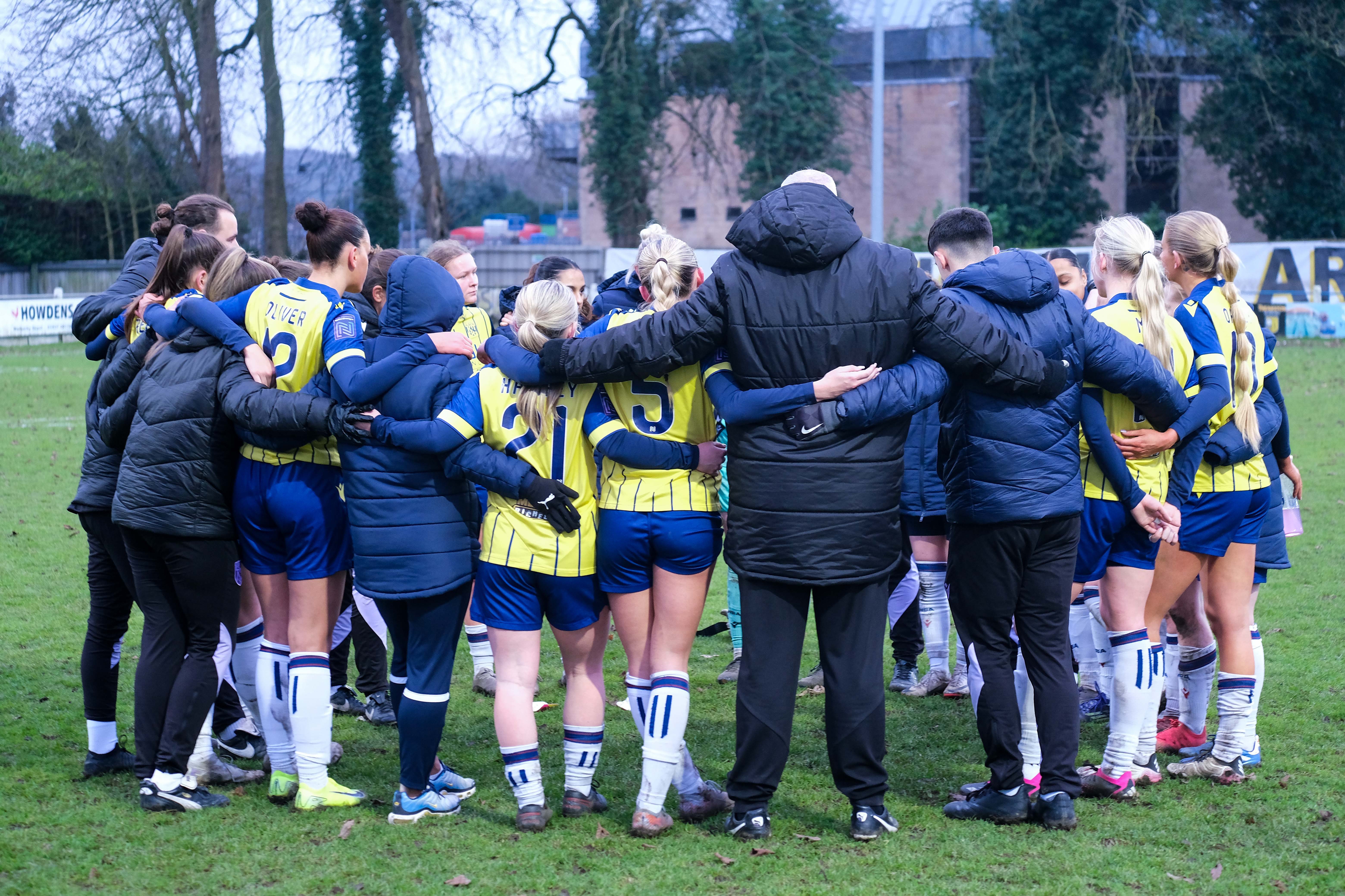 Albion Women players and staff in a huddle 