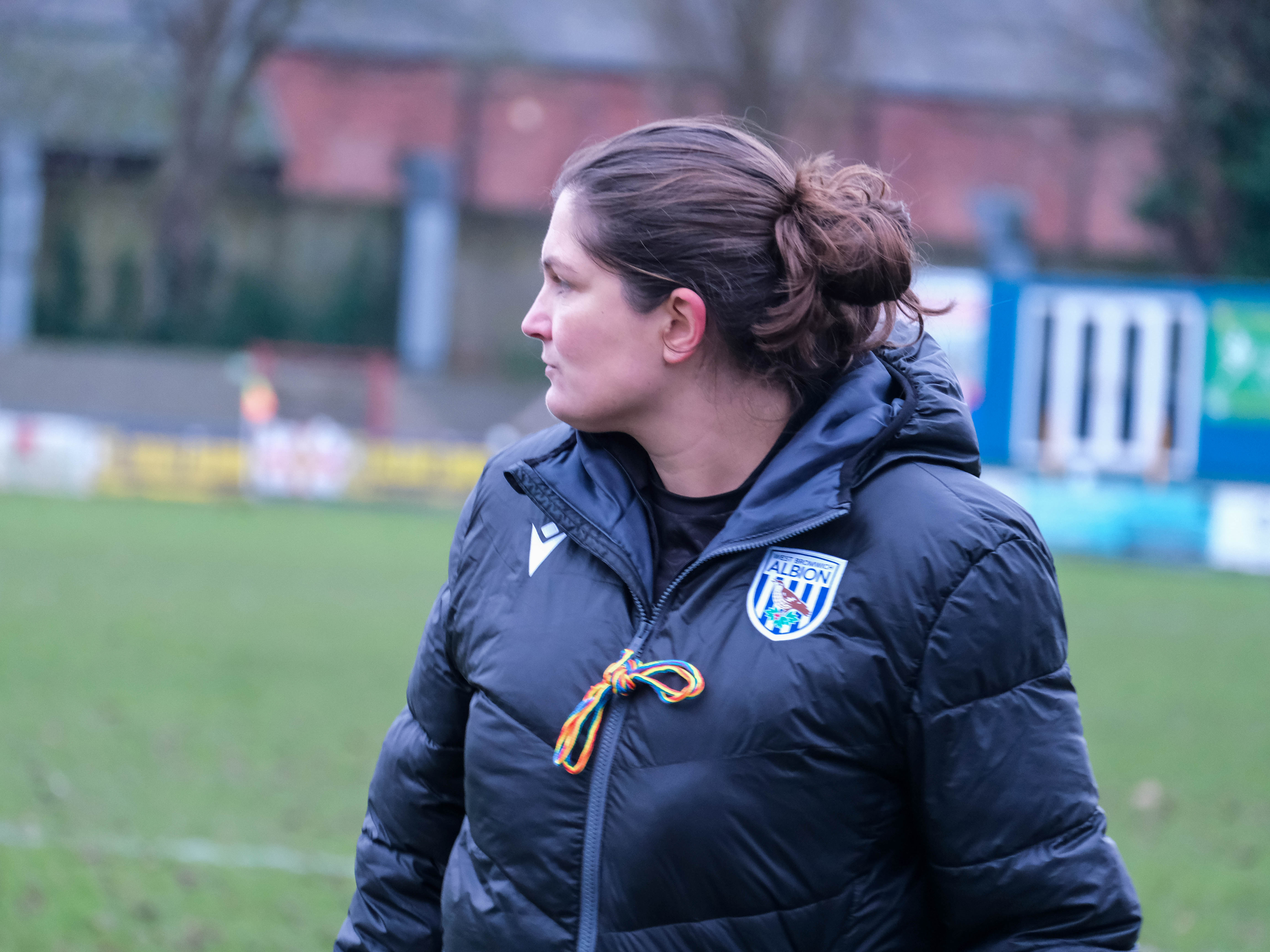 Siobhan Hodgetts-Still on the side of the pitch in a black Albion coat