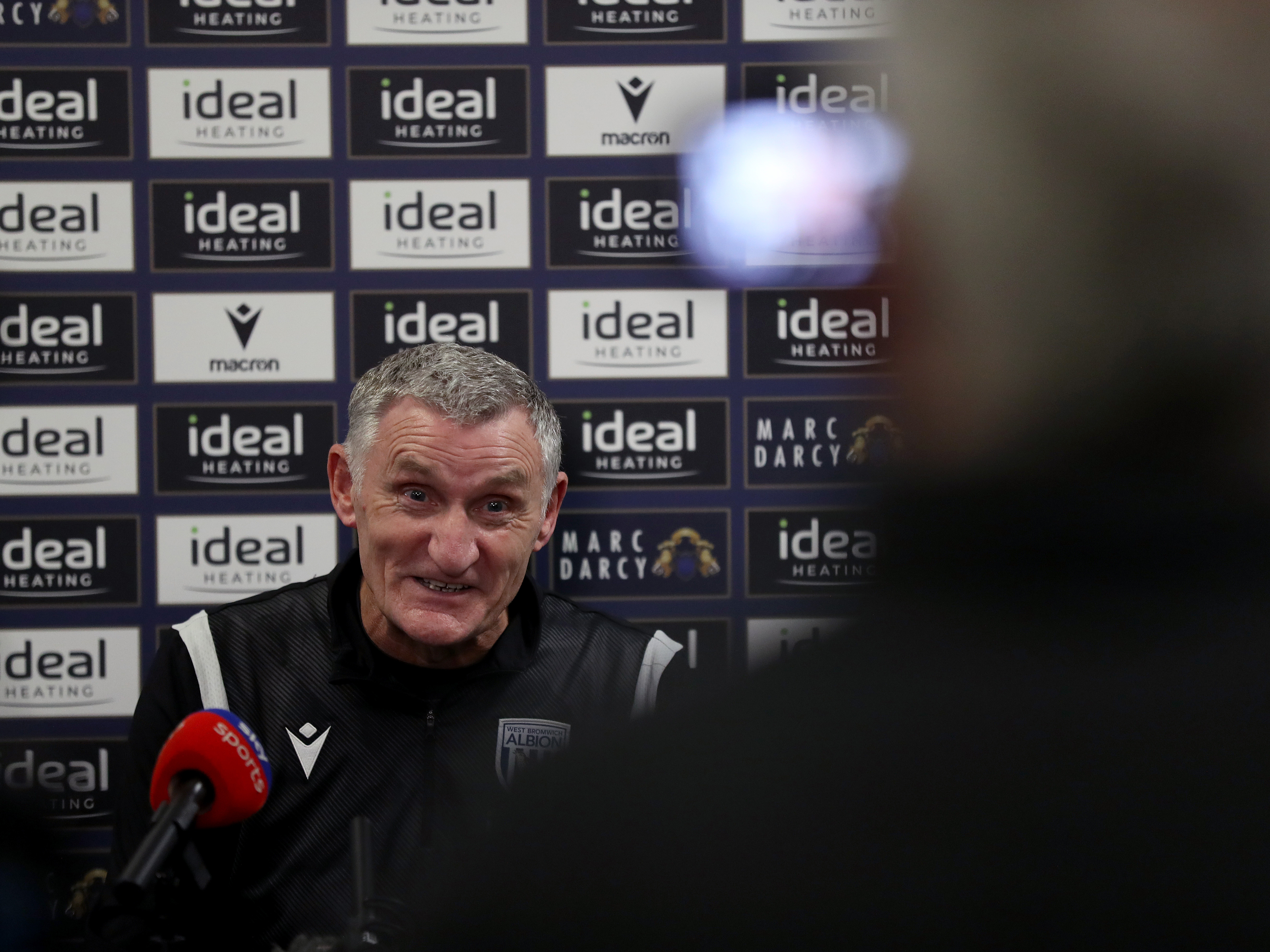 An image of Tony Mowbray smiling in a press conference