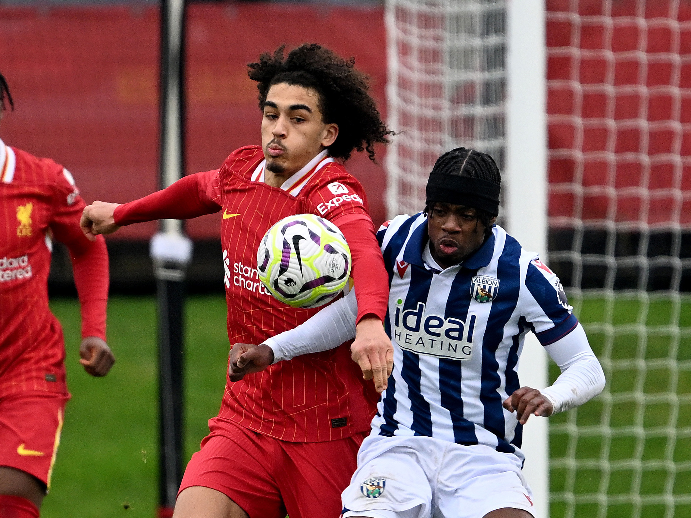 A photo of Albion U21 attacker Akeel Higgins in the 2024/25 home kit up against a Liverpool PL2 player