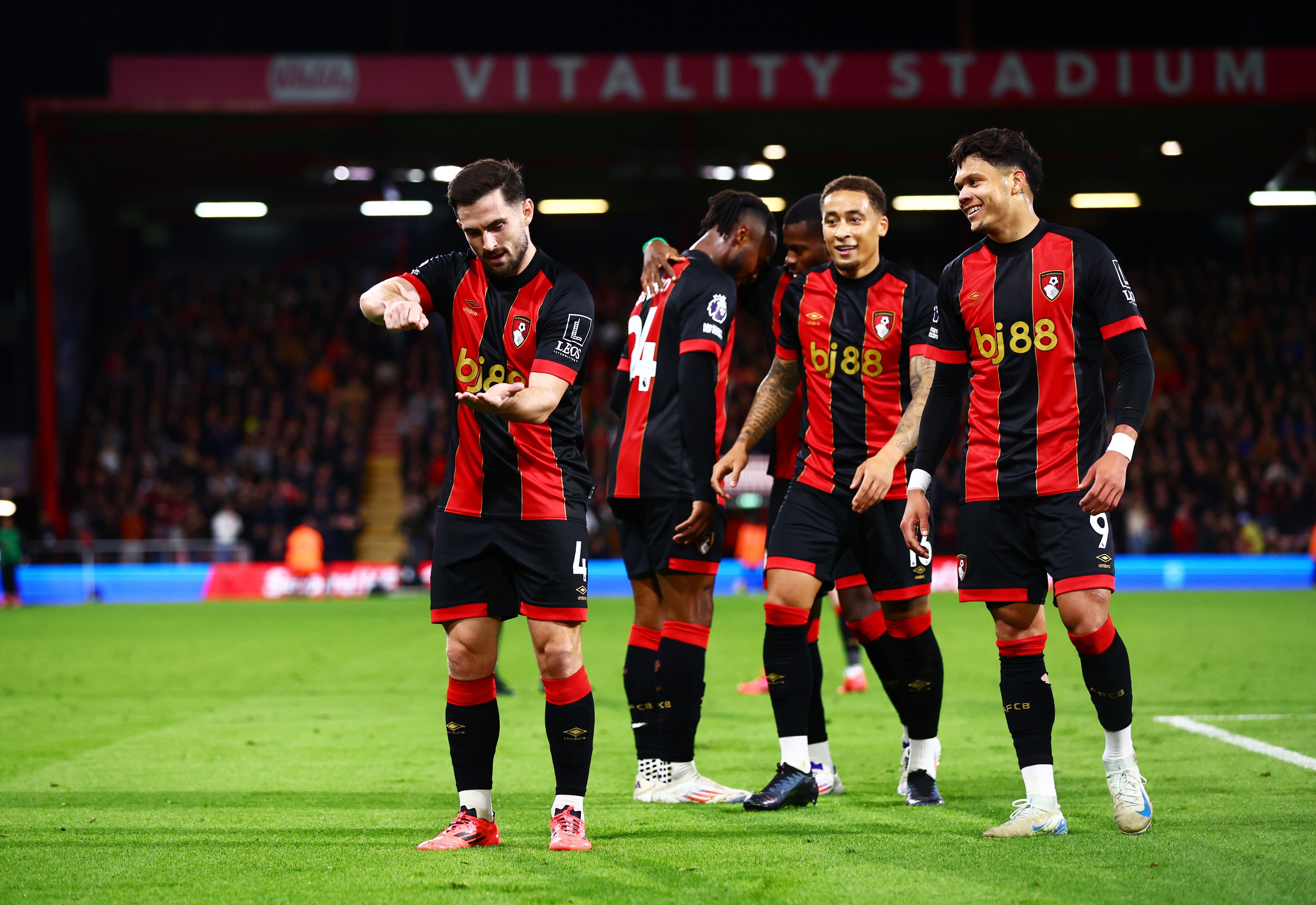 Several AFC Bournemouth players celebrate a goal of theirs in the home kit 