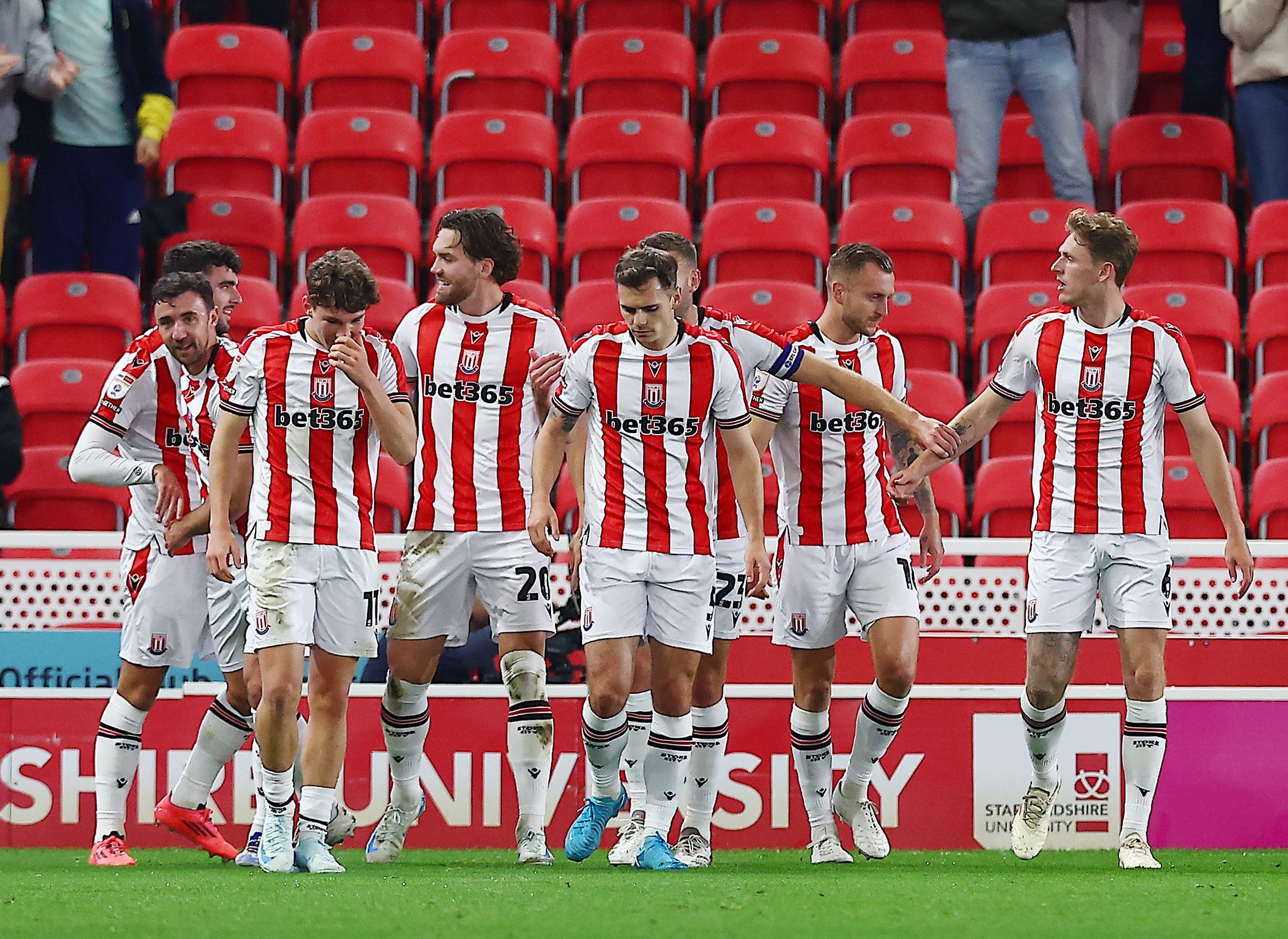 Several Stoke City players celebrate a goal in their home kit 