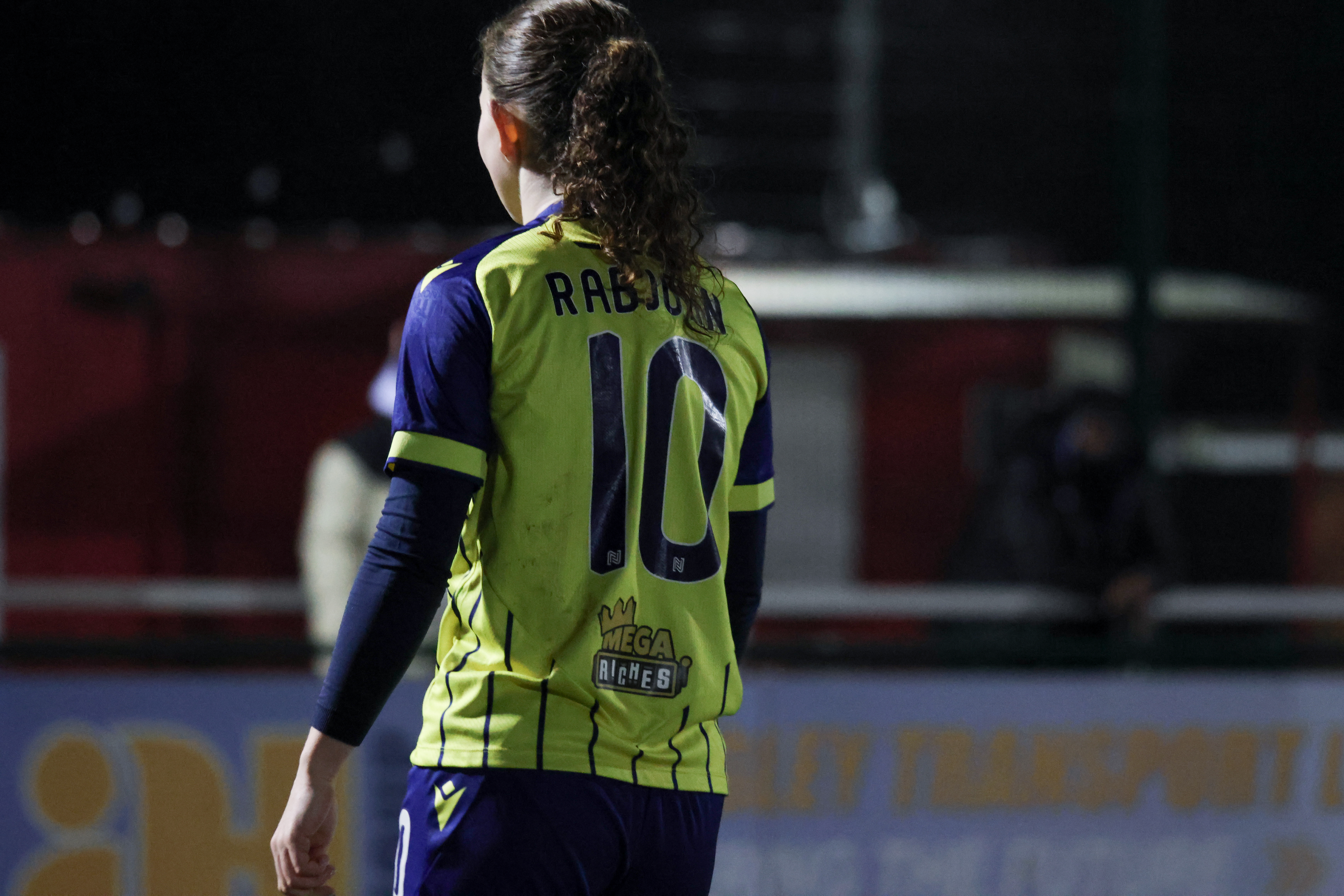 Olivia Rabjohn in action for Albion Women wearing the yellow and navy blue away kit 