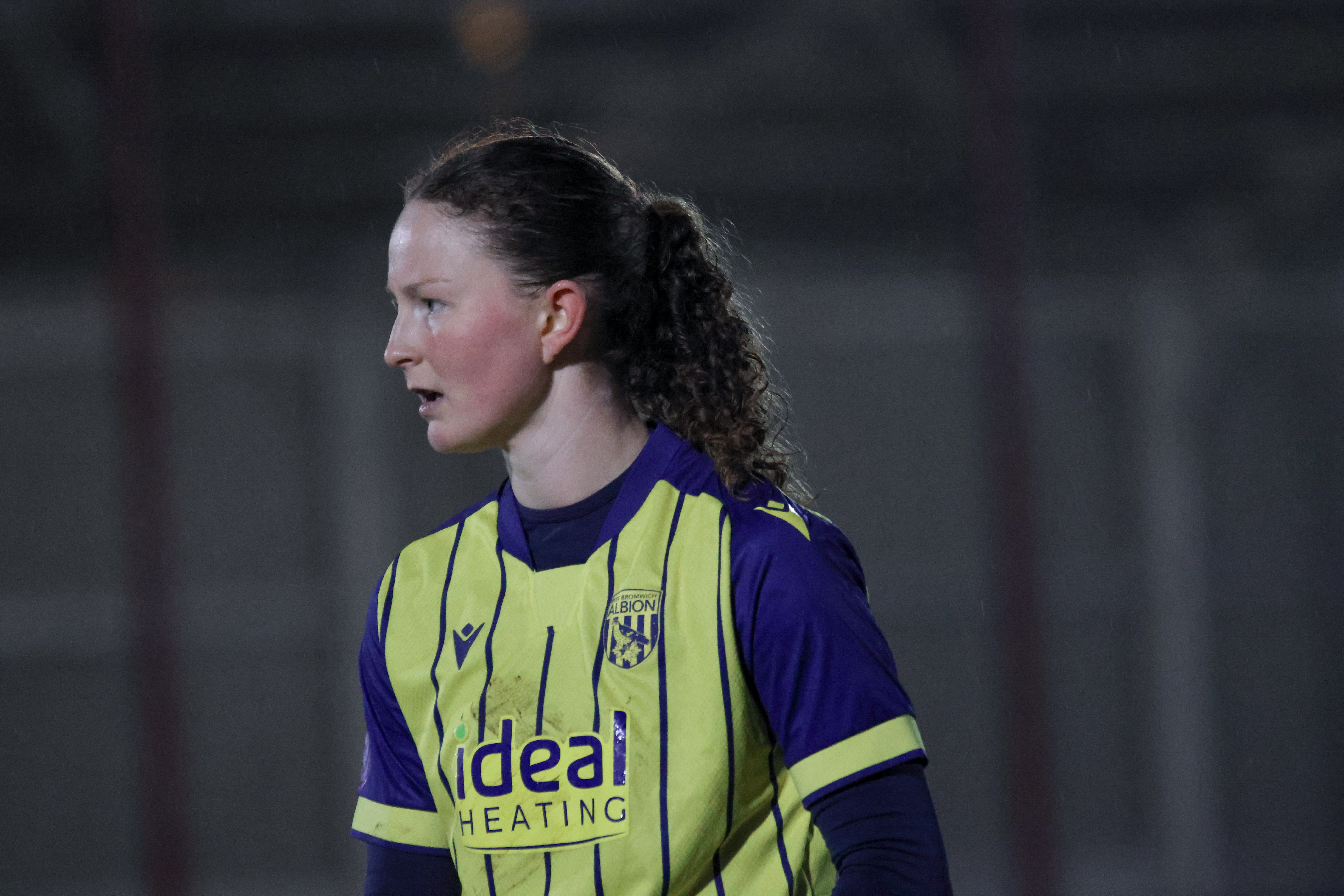 Olivia Rabjohn in action for Albion Women wearing the yellow and navy blue away kit