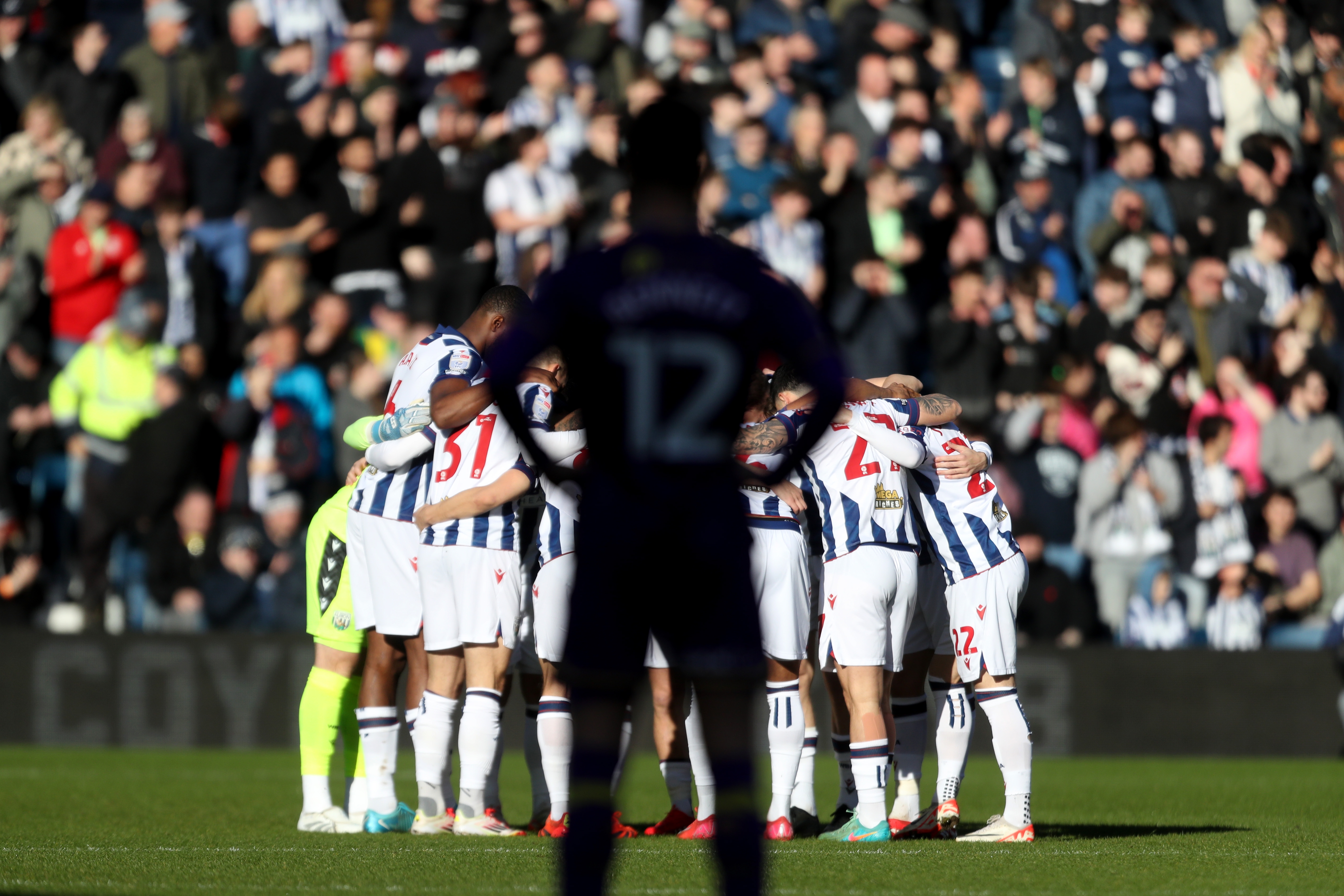 The Albion team in a huddle before the Oxford game at The Hawthorns