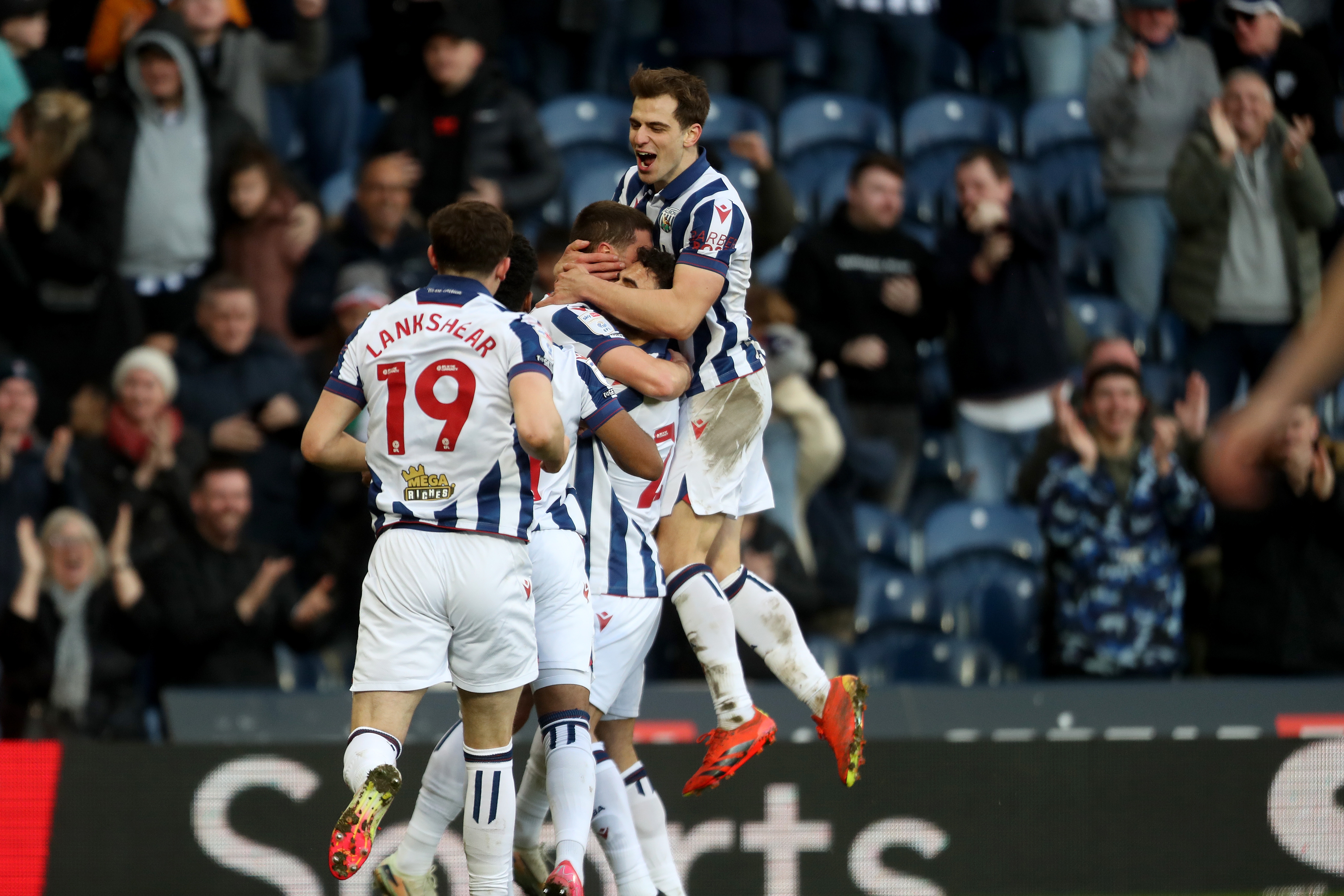 John Swift celebrates scoring against Oxford at The Hawthorns with team-mates