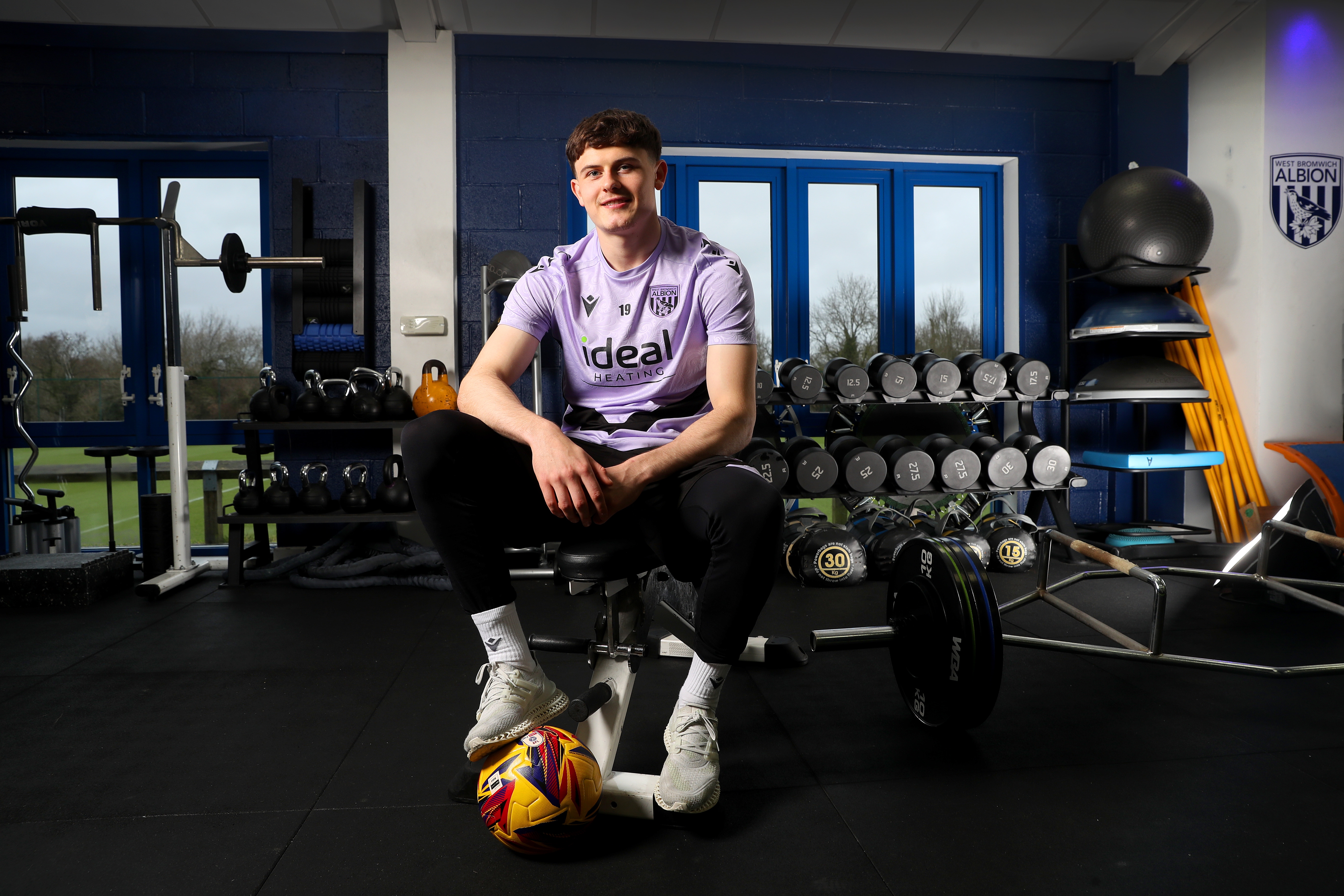 Will Lankshear sat in the gym in training kit with his foot on a yellow ball