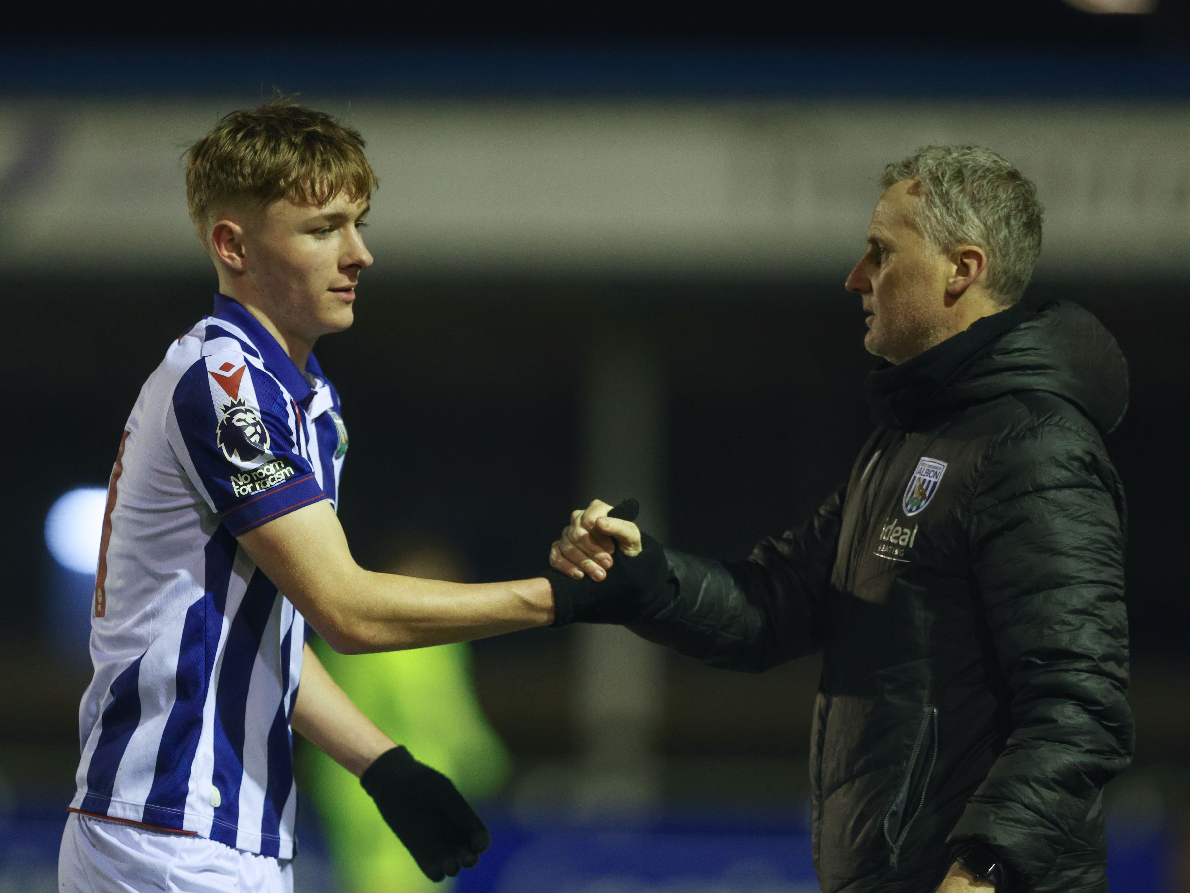 A photo of Albion academy player Ollie Bostock and U21s boss Richard Beale shaking hands 