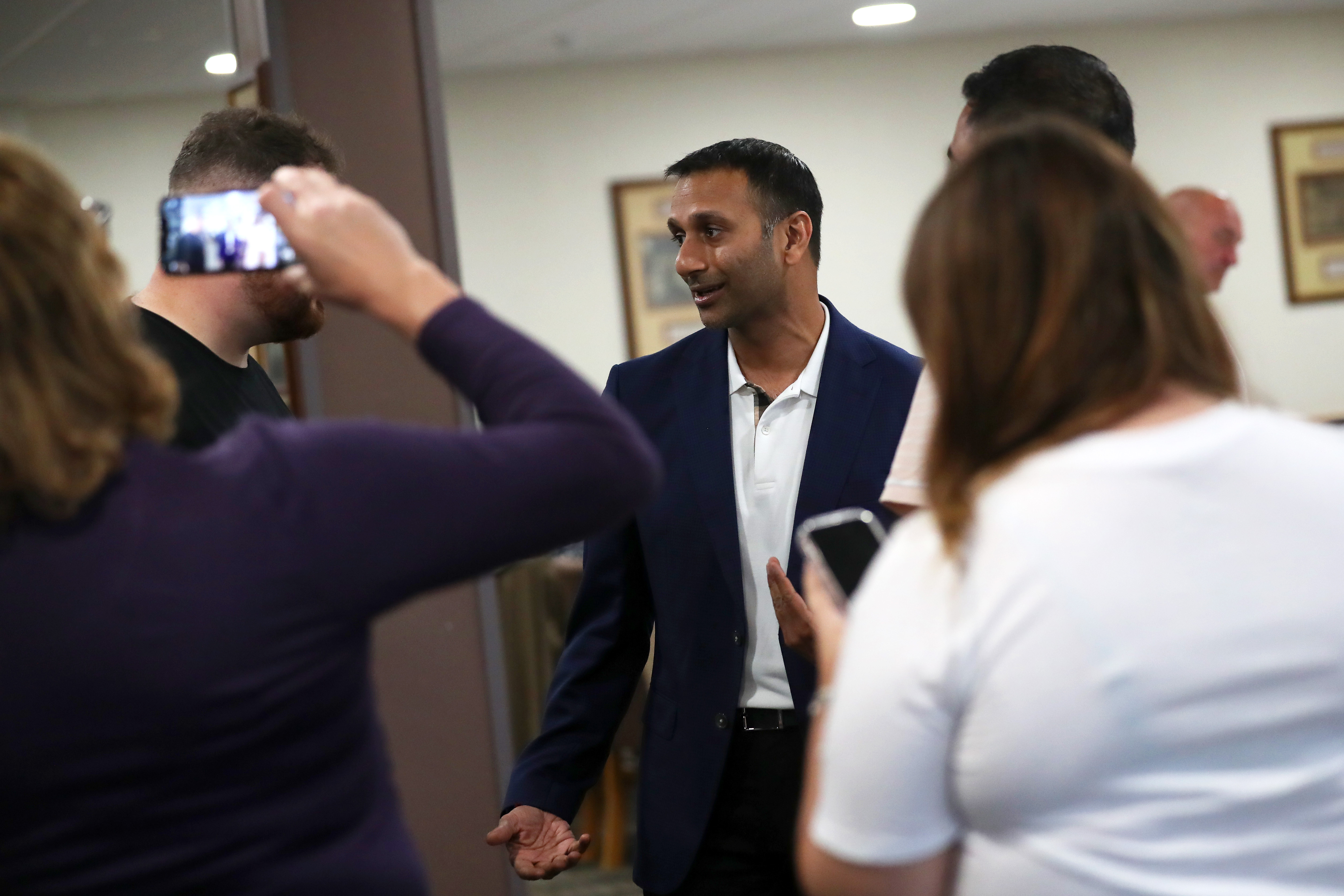 Chairman Shilen Patel involved in a conversation with supporters while wearing a suit 