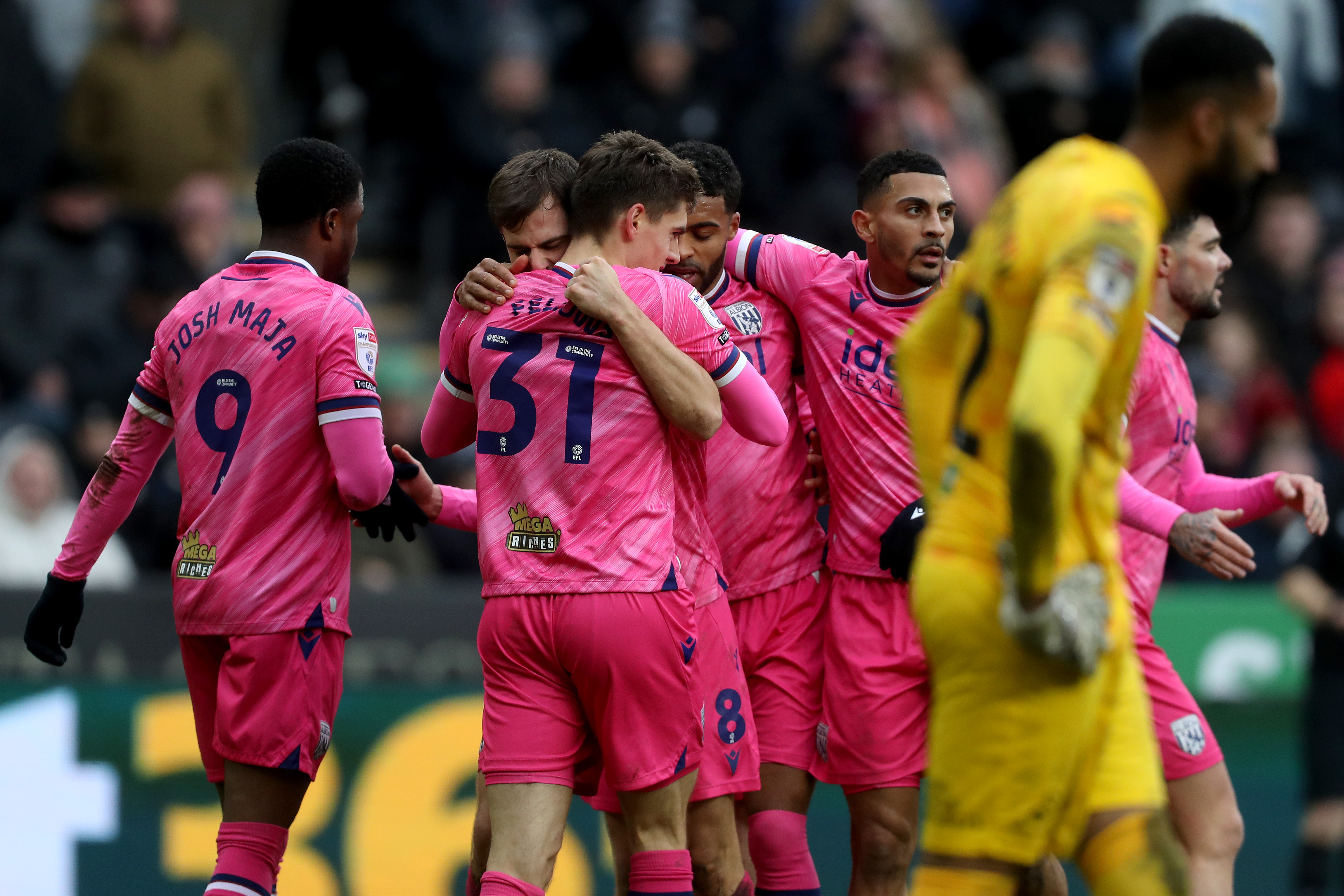 Several Albion players celebrate Tom Fellows' goal at Swansea while wearing the pink kit 