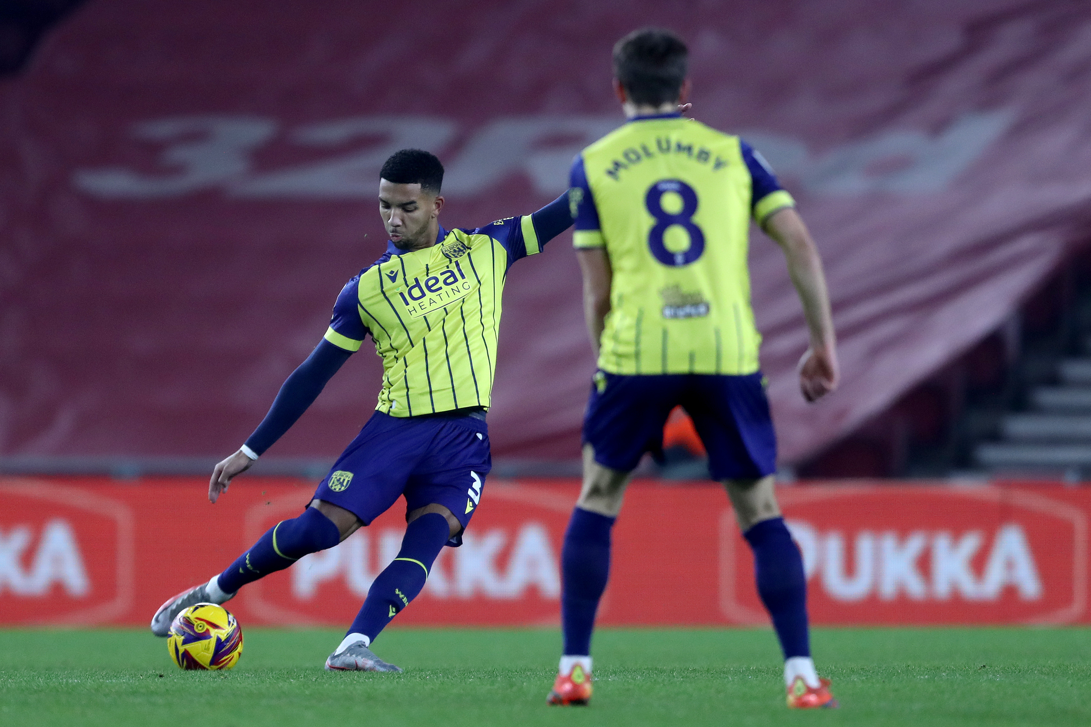 Mason Holgate striking the ball in the yellow and navy blue away kit against Middlesbrough