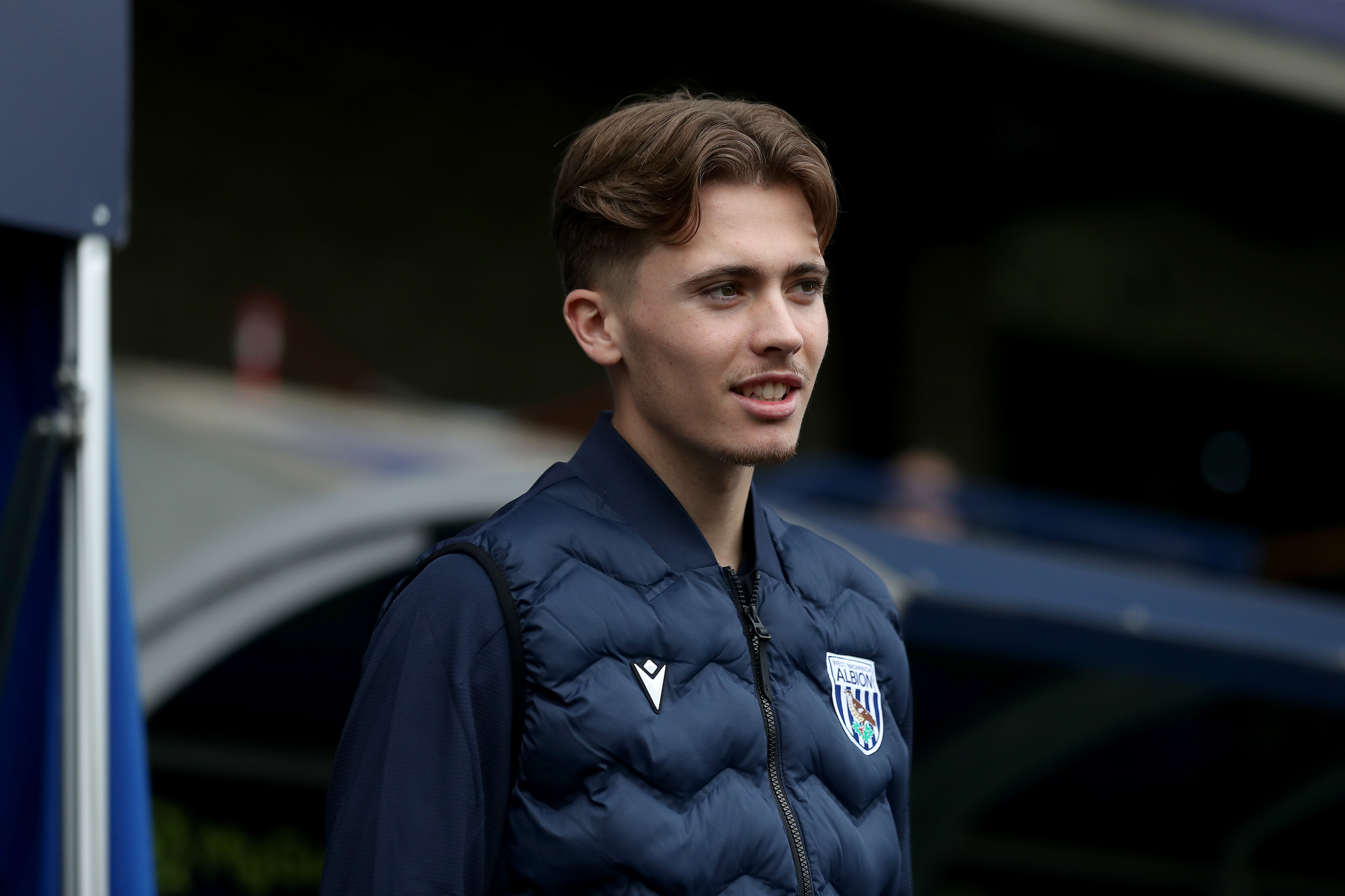 Isaac Price smiling while wearing a WBA tracksuit 