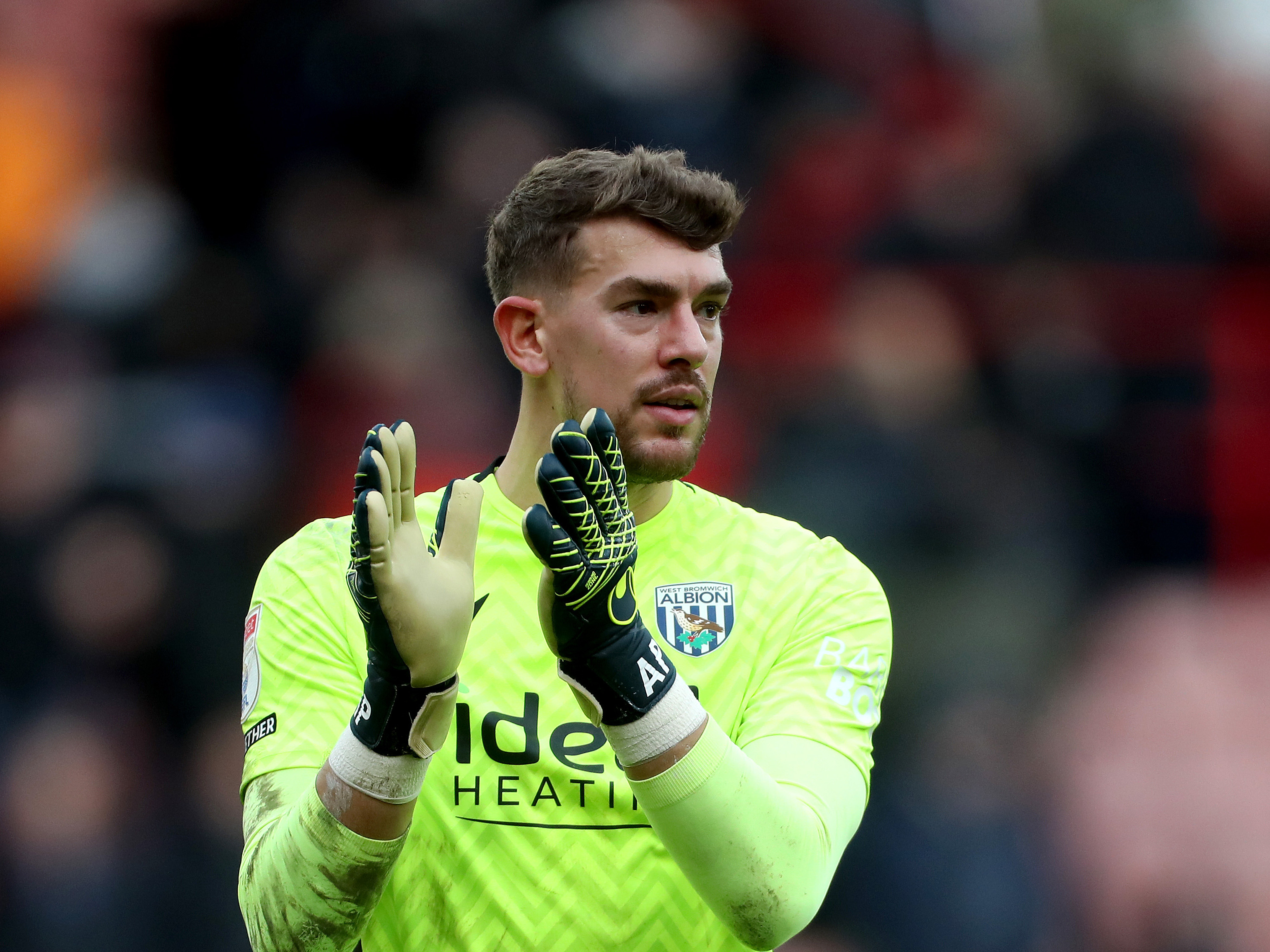 Alex Palmer applauding WBA fans in a lime green kit 