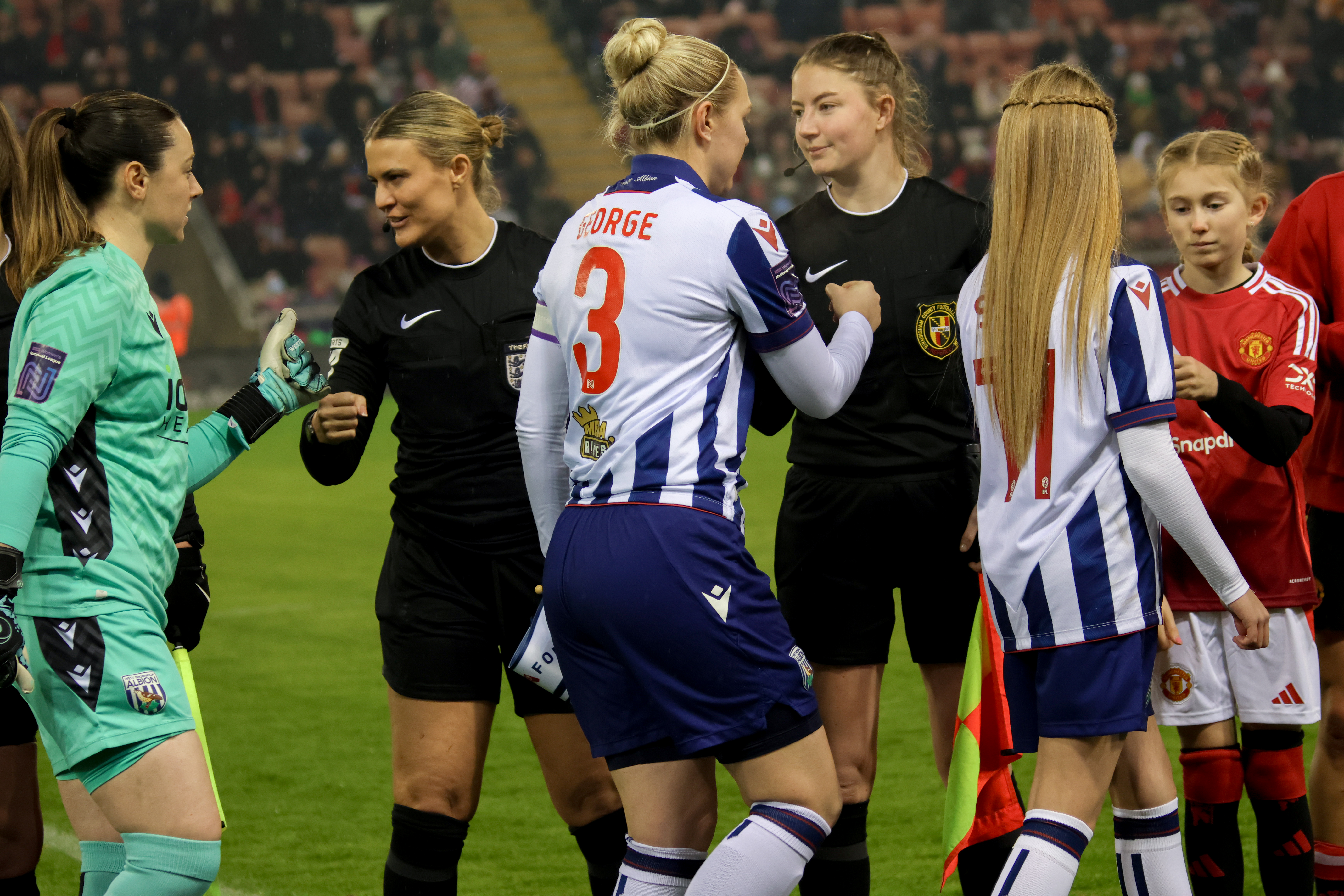 Hannah George in the home kit shaking hands with the referee before the Manchester United game 