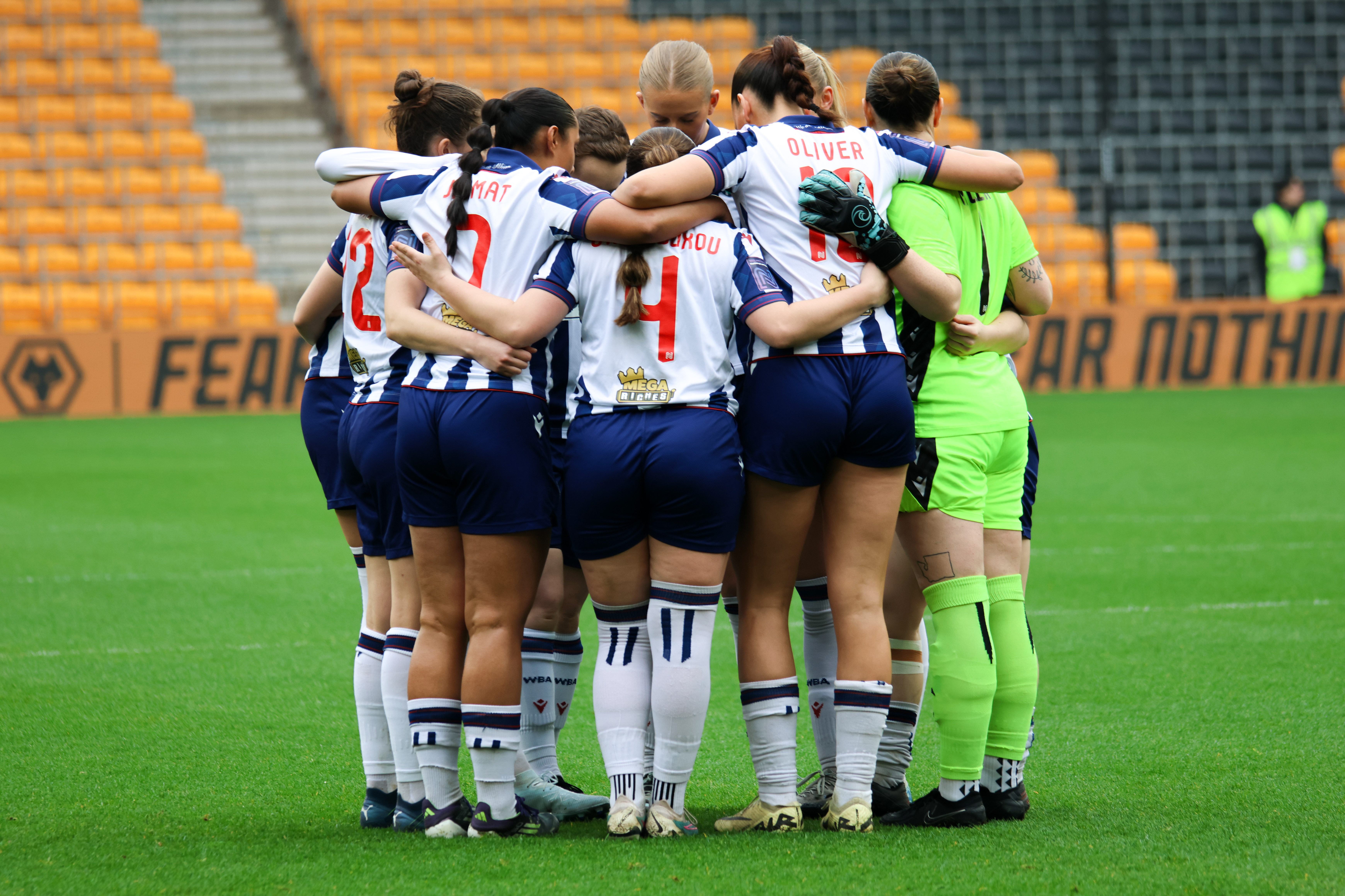 Albion Women in a team huddle before the game at Wolves