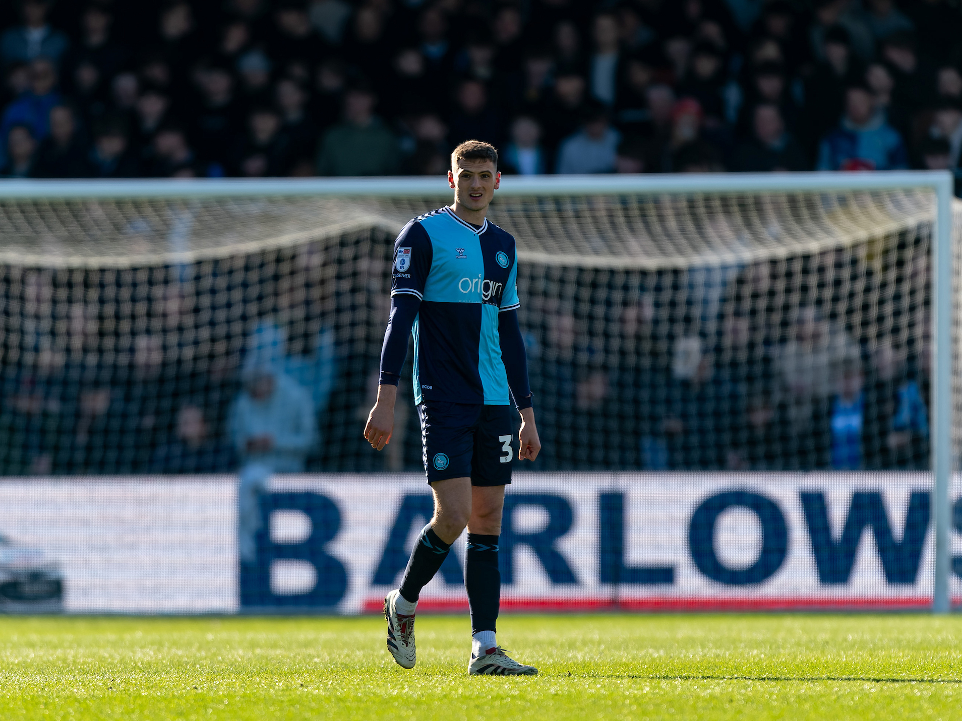 A photo of Albion defender Caleb Taylor in action for loan club Wycombe, wearing their light blue and navy home kit