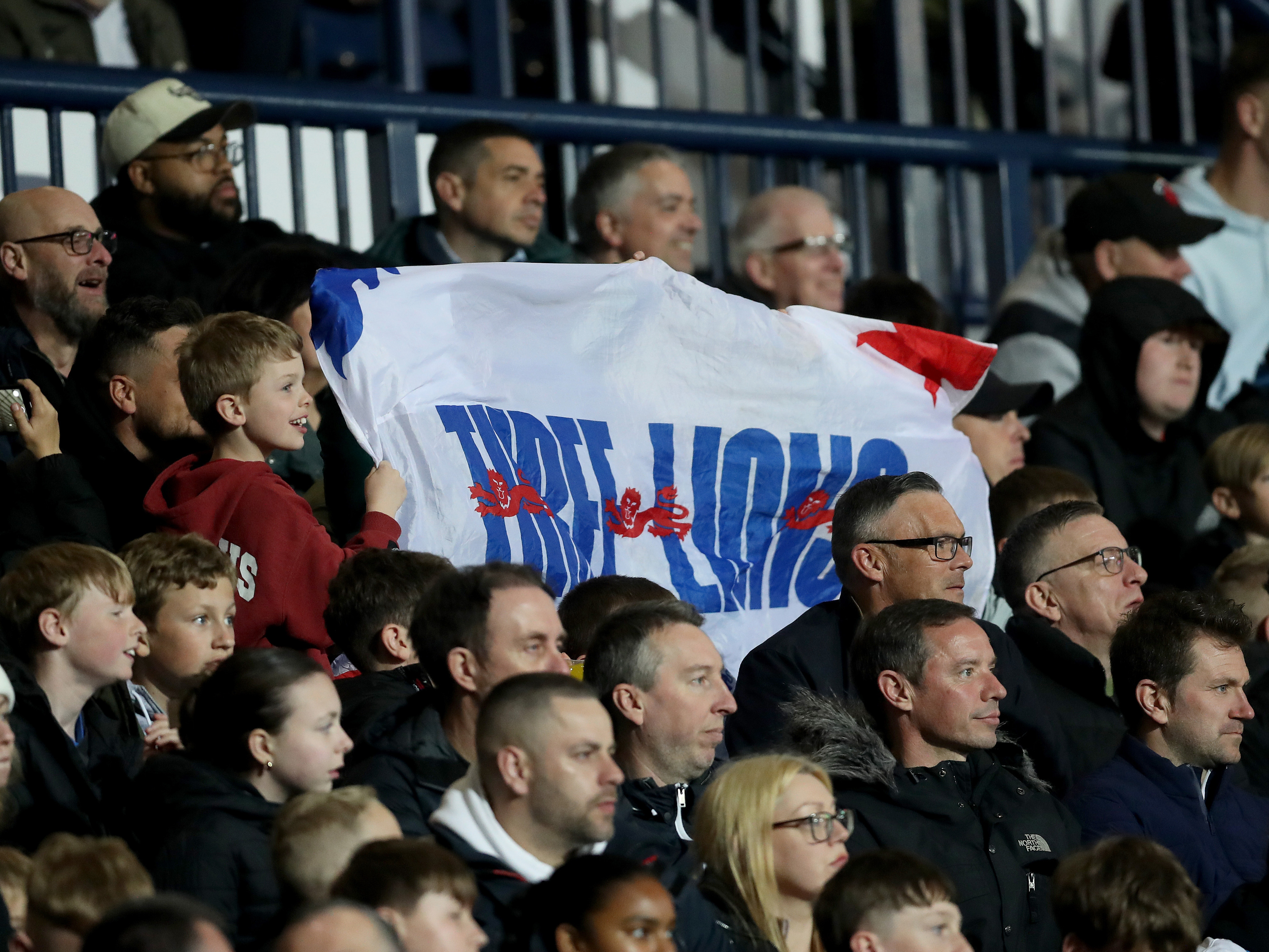 An England fan at The Hawthorns holding up a Three Lions flag