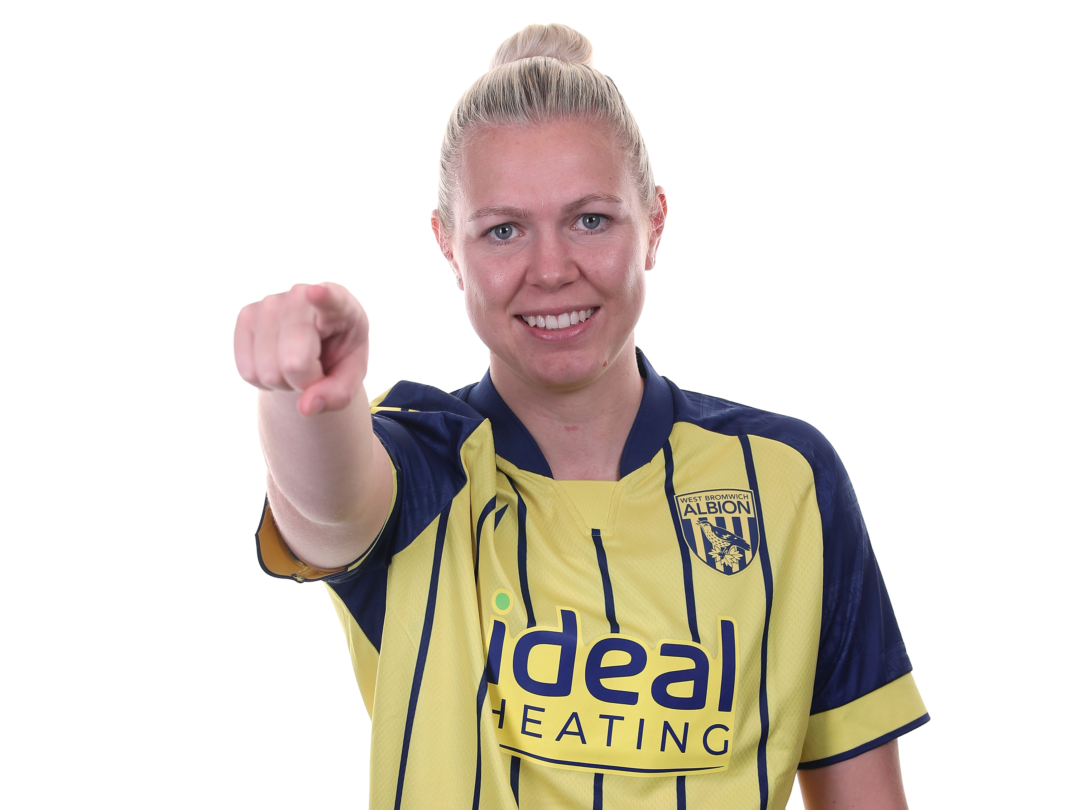 Hannah George pointing and smiling at the camera while wearing a yellow away shirt 