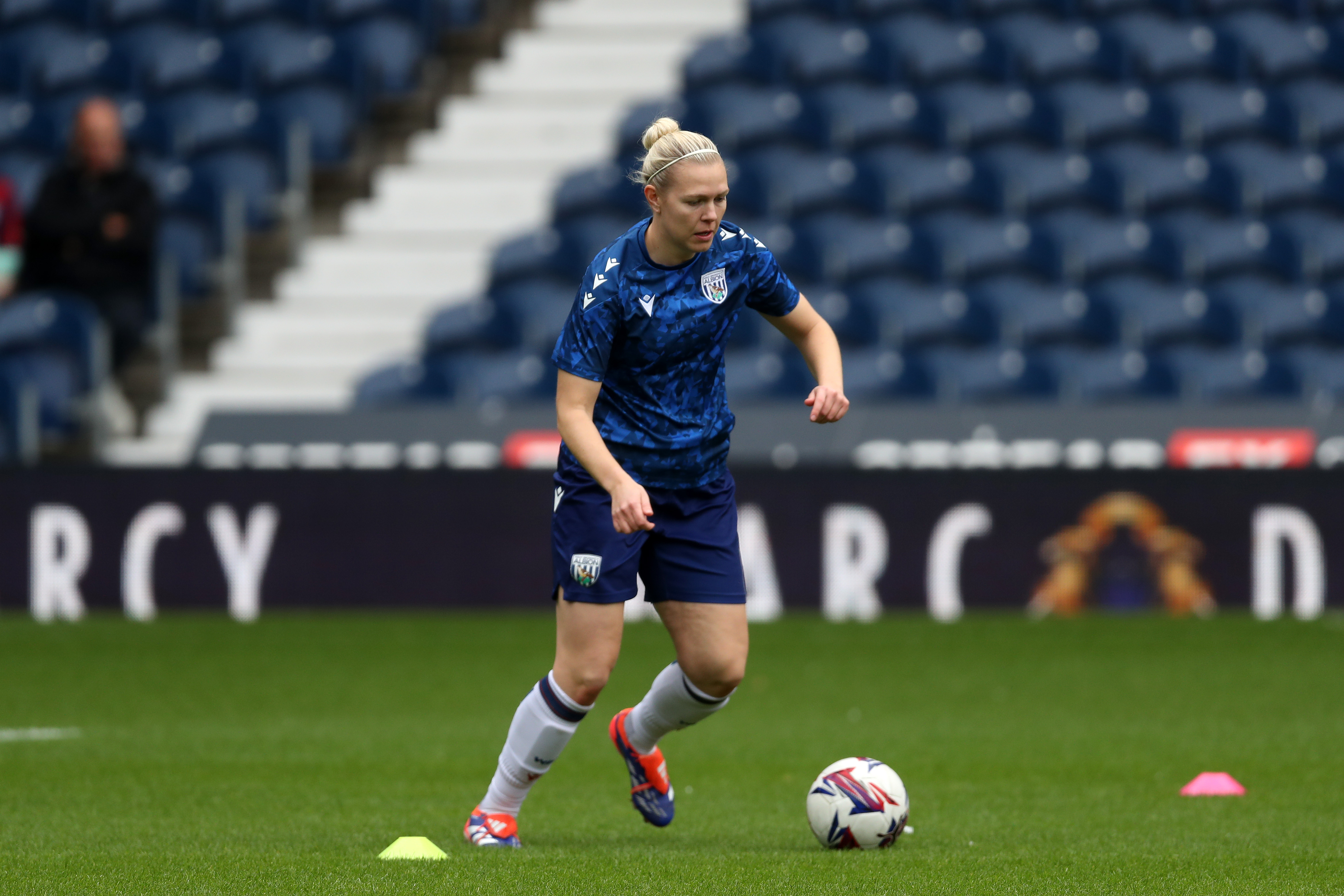 Hannah George warming up before a game at The Hawthorns with the ball at her feet