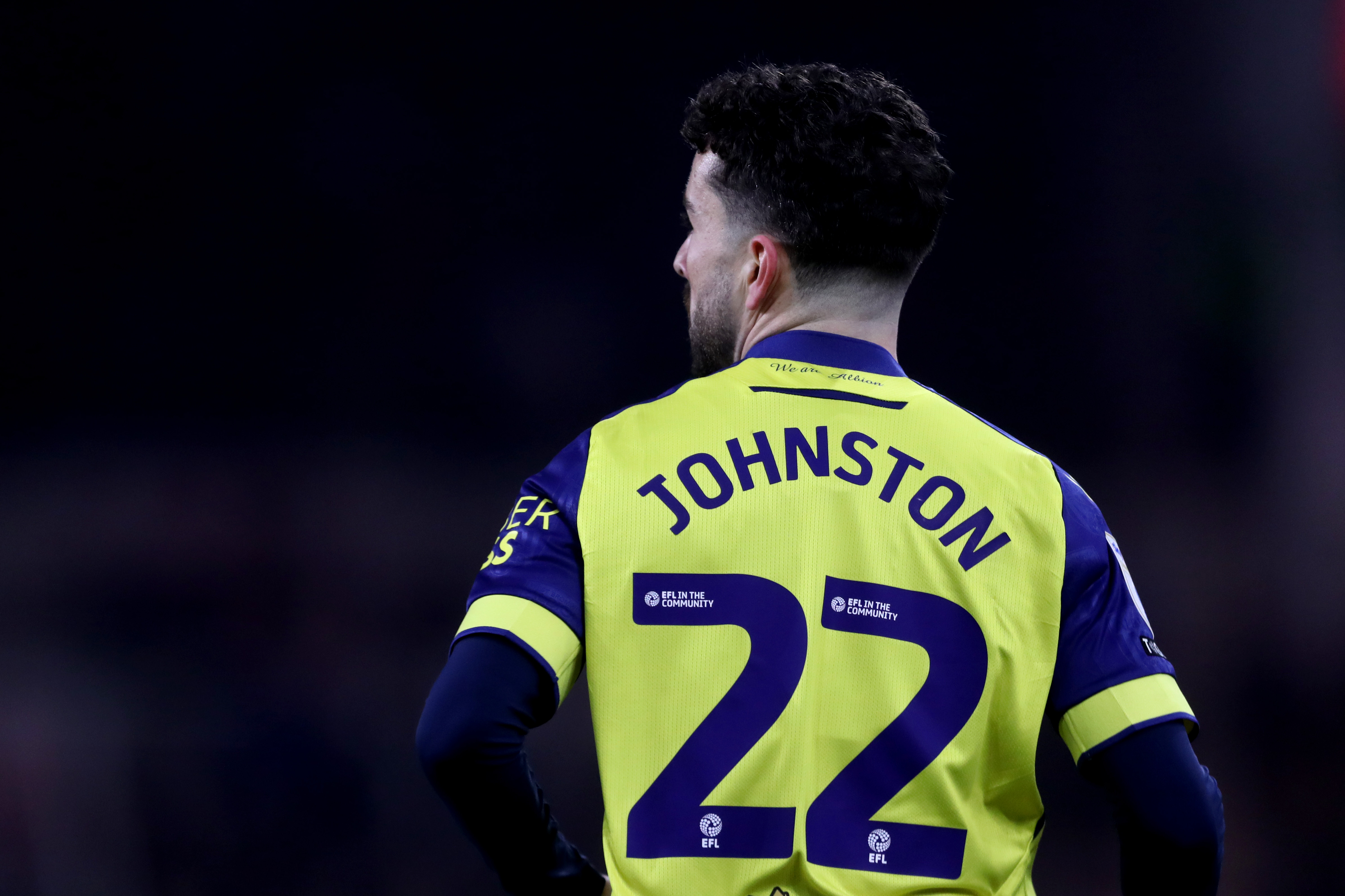 The back of Mikey Johnston while wearing the yellow and navy blue away kit with his name and number 22 on show 