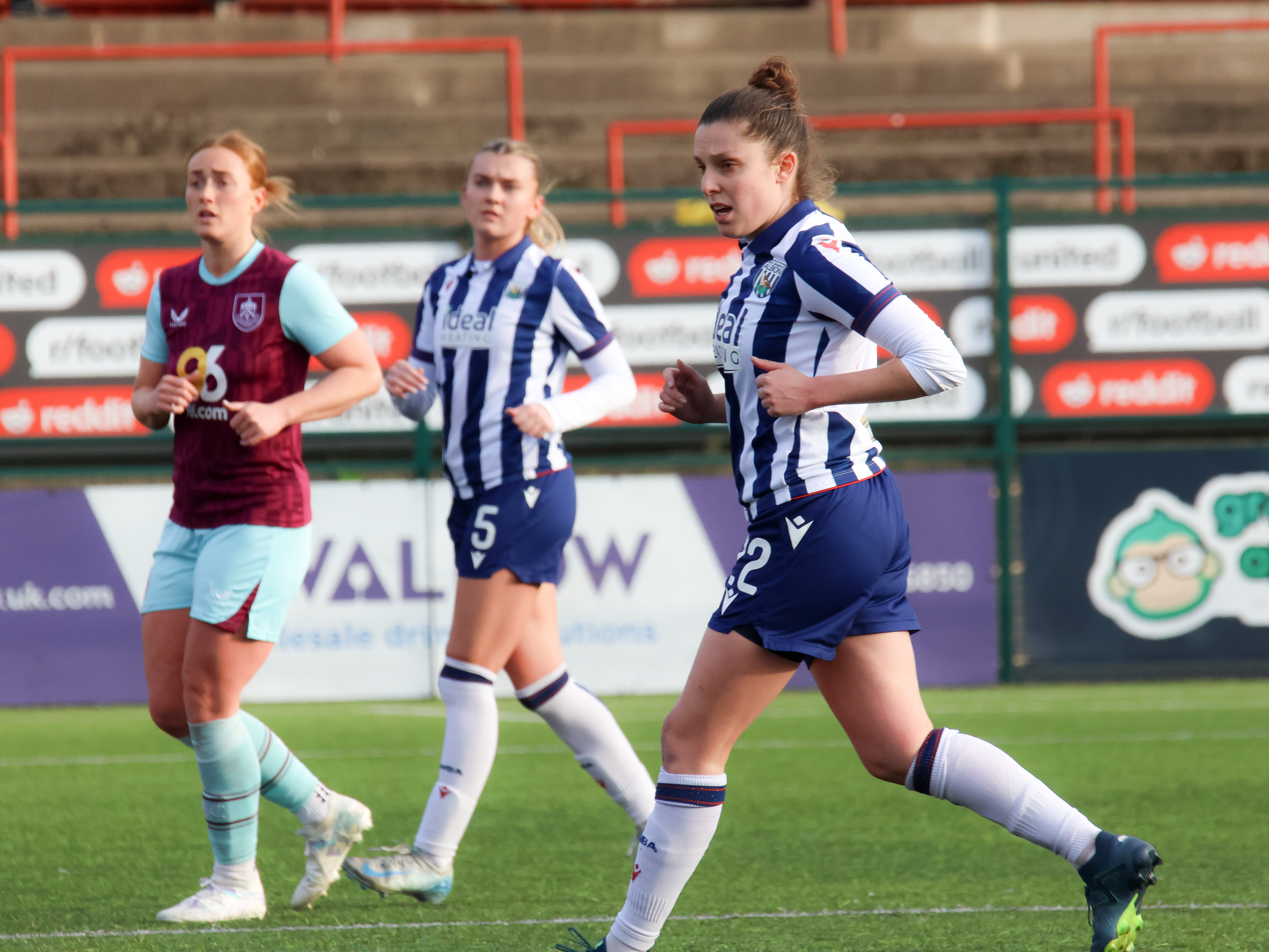 An image of Kate Evans playing against Burnley for Albion Women